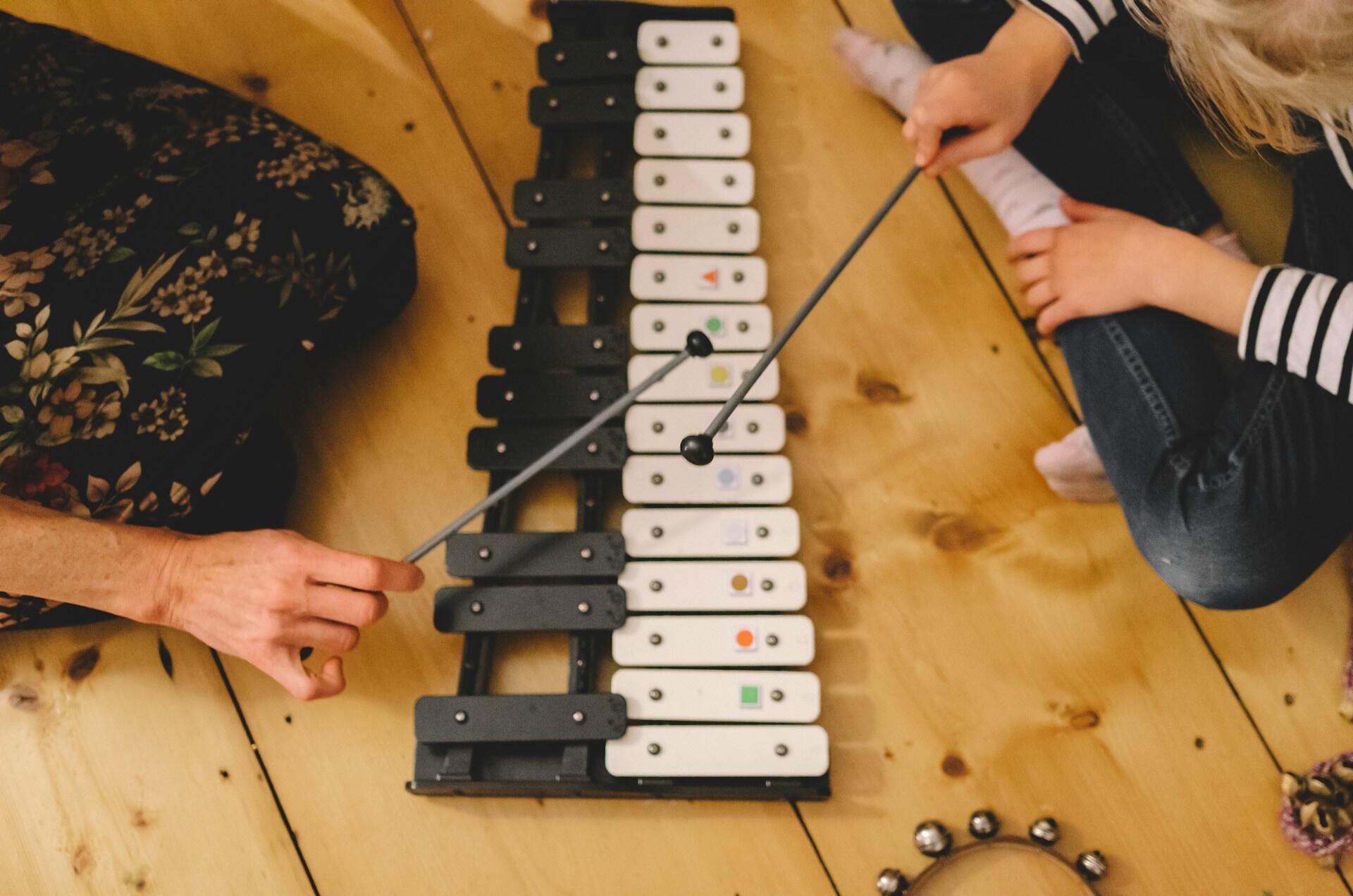 Frau und Kind spielen gemeinsam auf einem Instrument. |Quelle: Aarón Blanco Tejedor