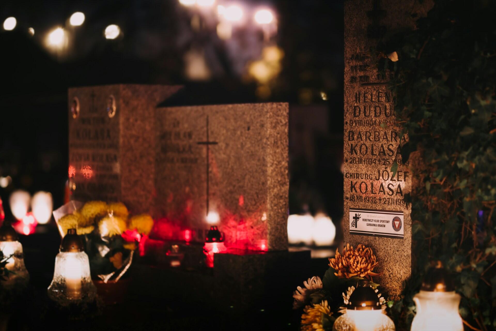 Gräber geschmückt mit Kerzen und Blumen.