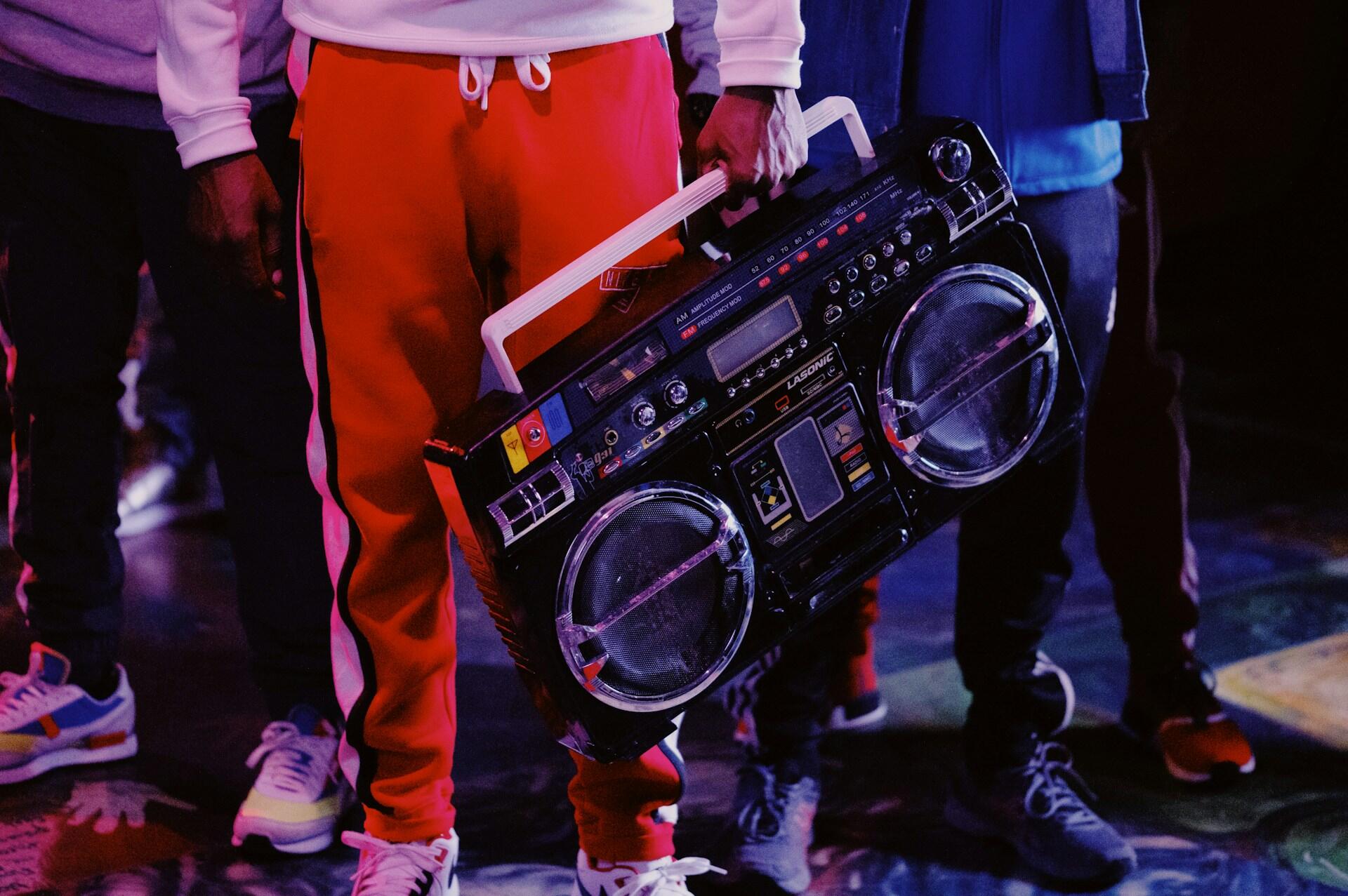 Mann mit roter Hose, der einen Ghettoblaster trägt. |Quelle: Gordon Cowie