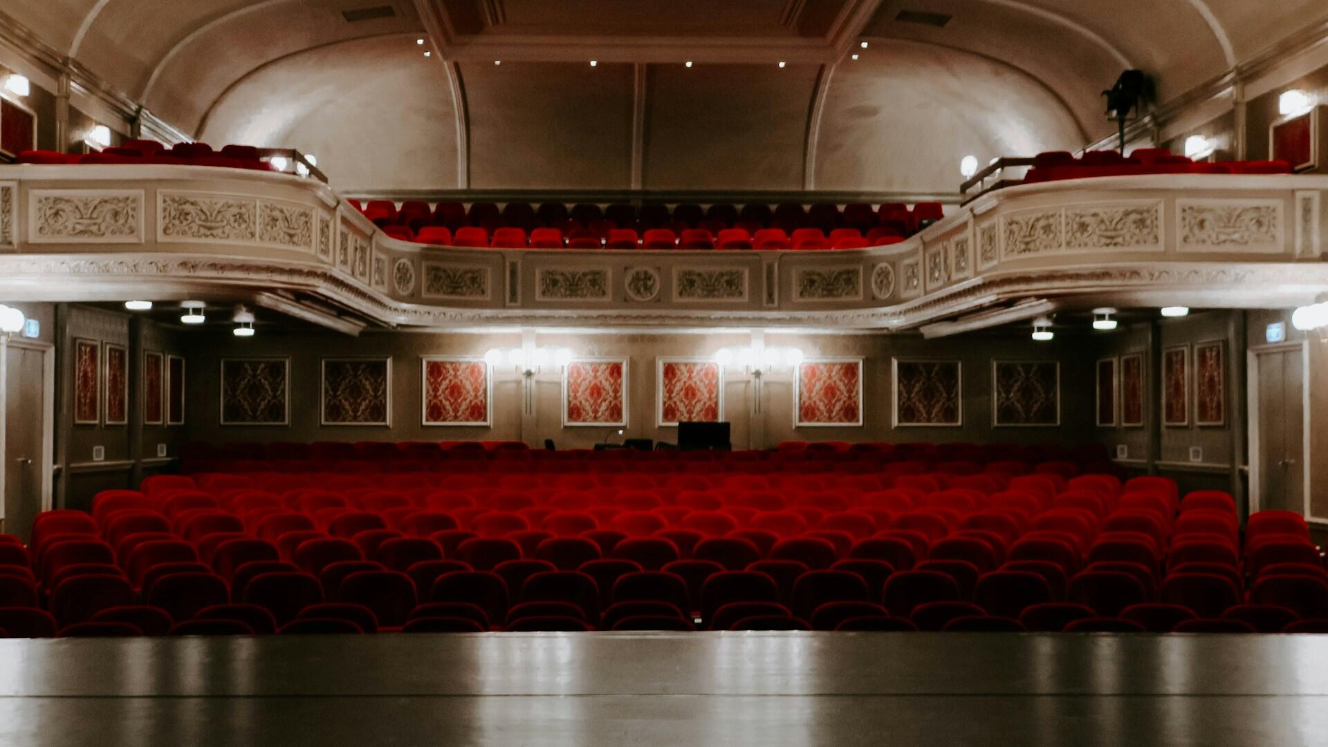 Rote Theaterstühle in einem weißen Theater