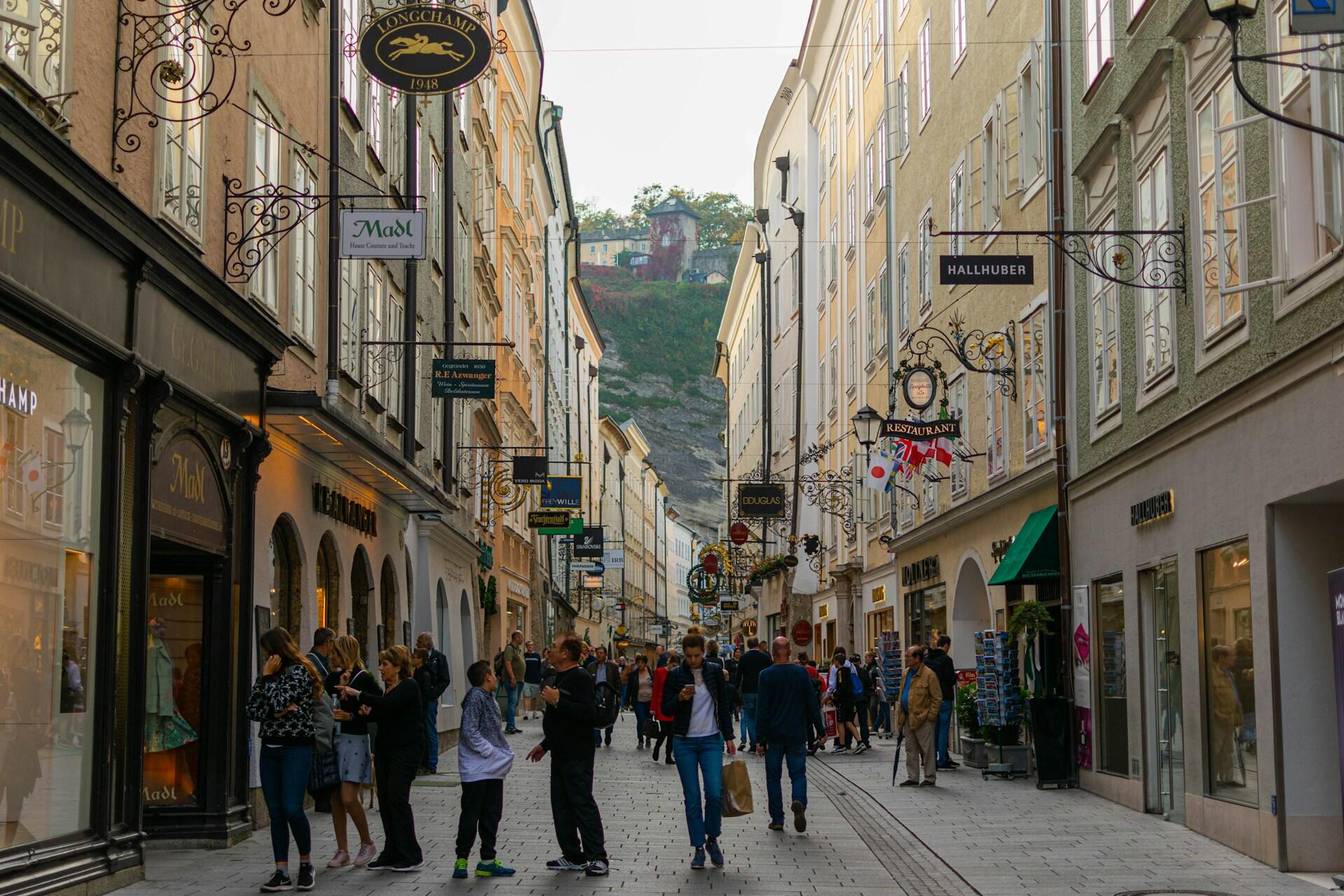 Menschen laufen durch die Straße einer Innenstadt.