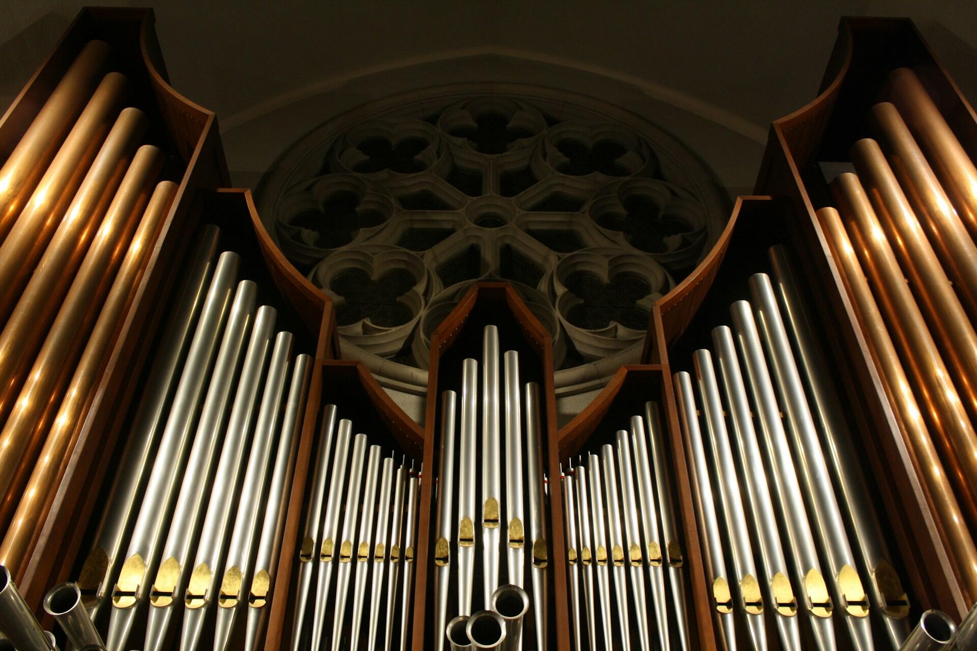 Braune Orgel vor einem Kirchenfenster