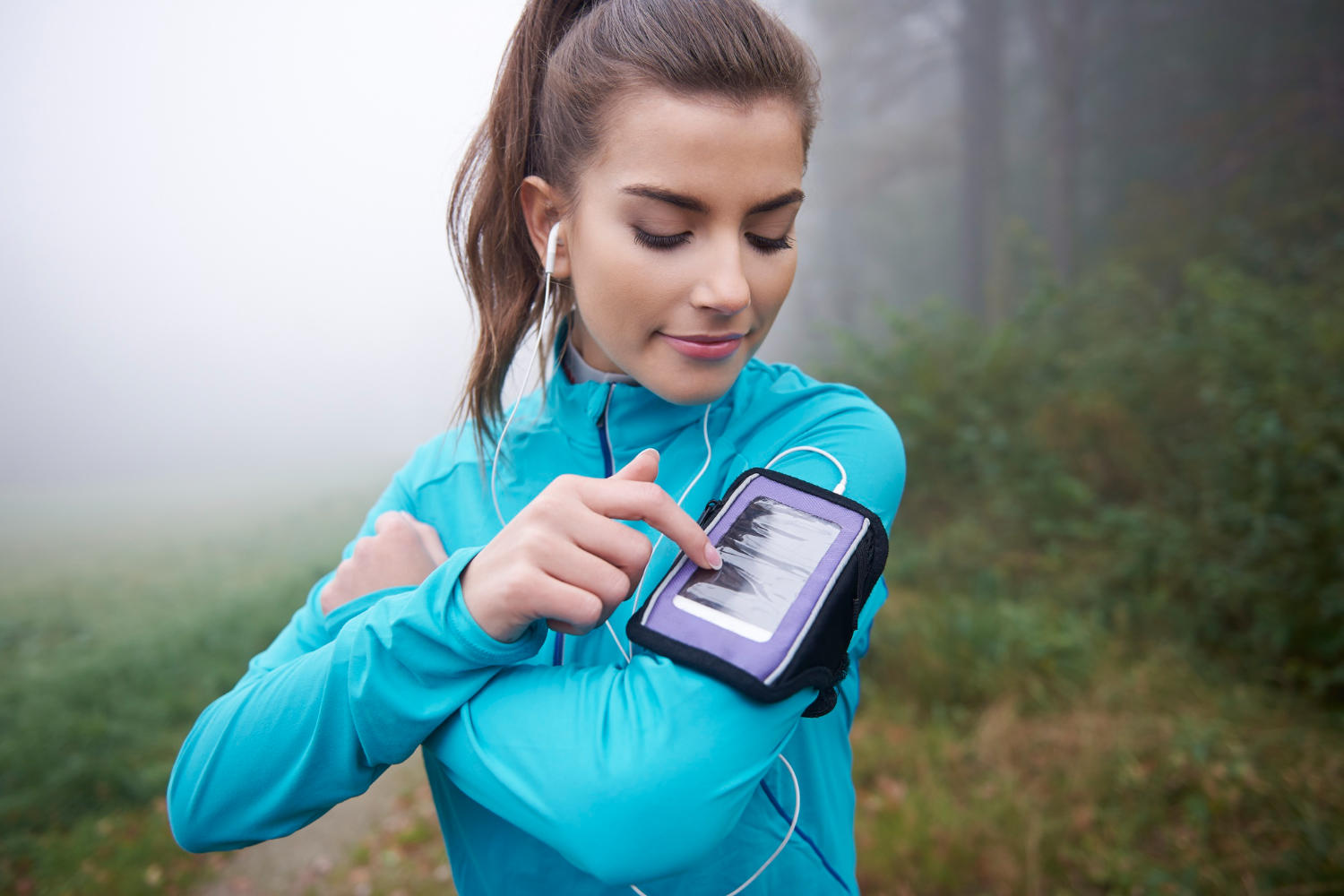A runner setting up her app on her phone before her workout