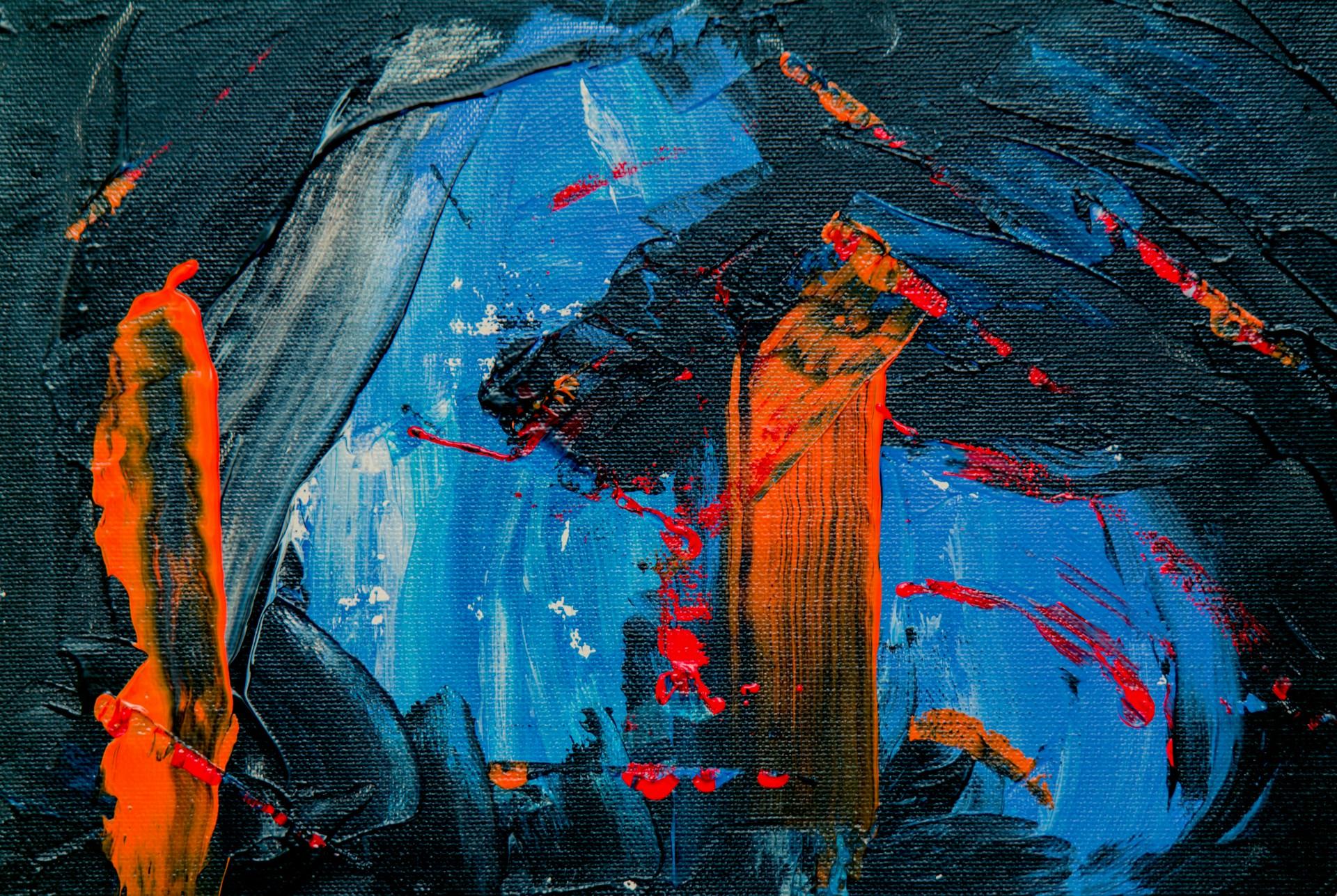 Close up image of a blue, black and orange abstract painting