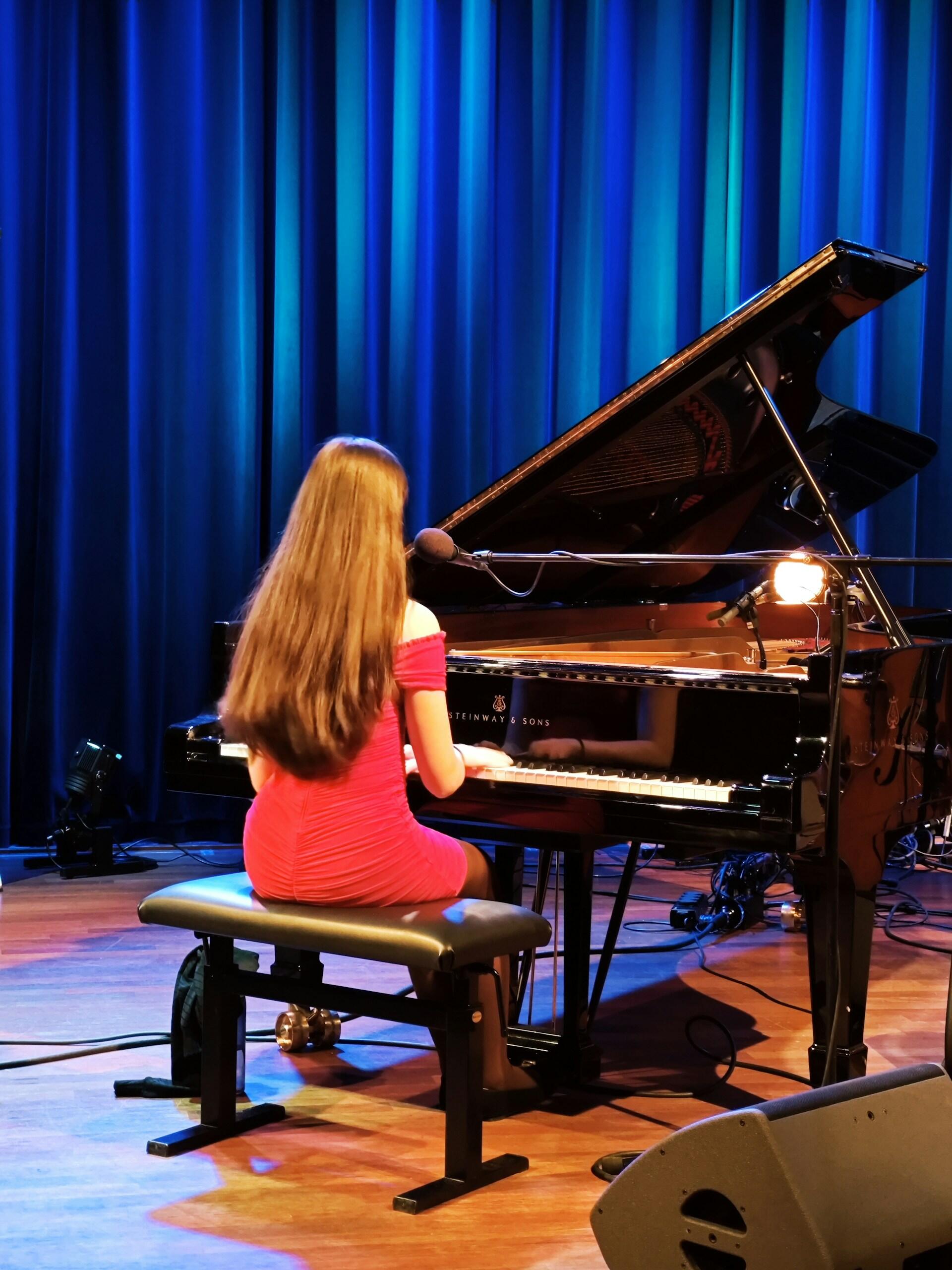 A woman on stage with a piano.