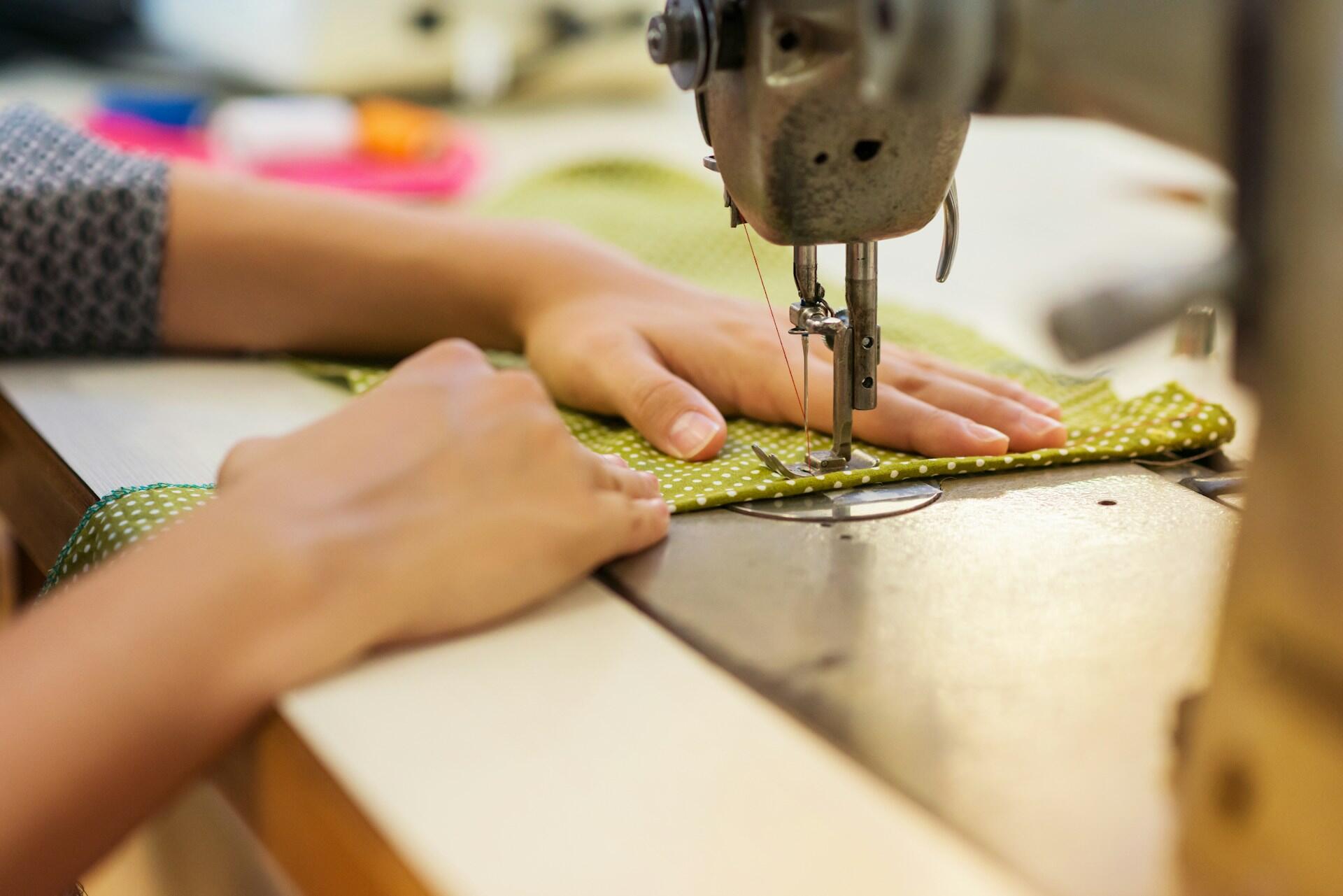 a young person using a sewing machine to make stitches on a piece of fabric