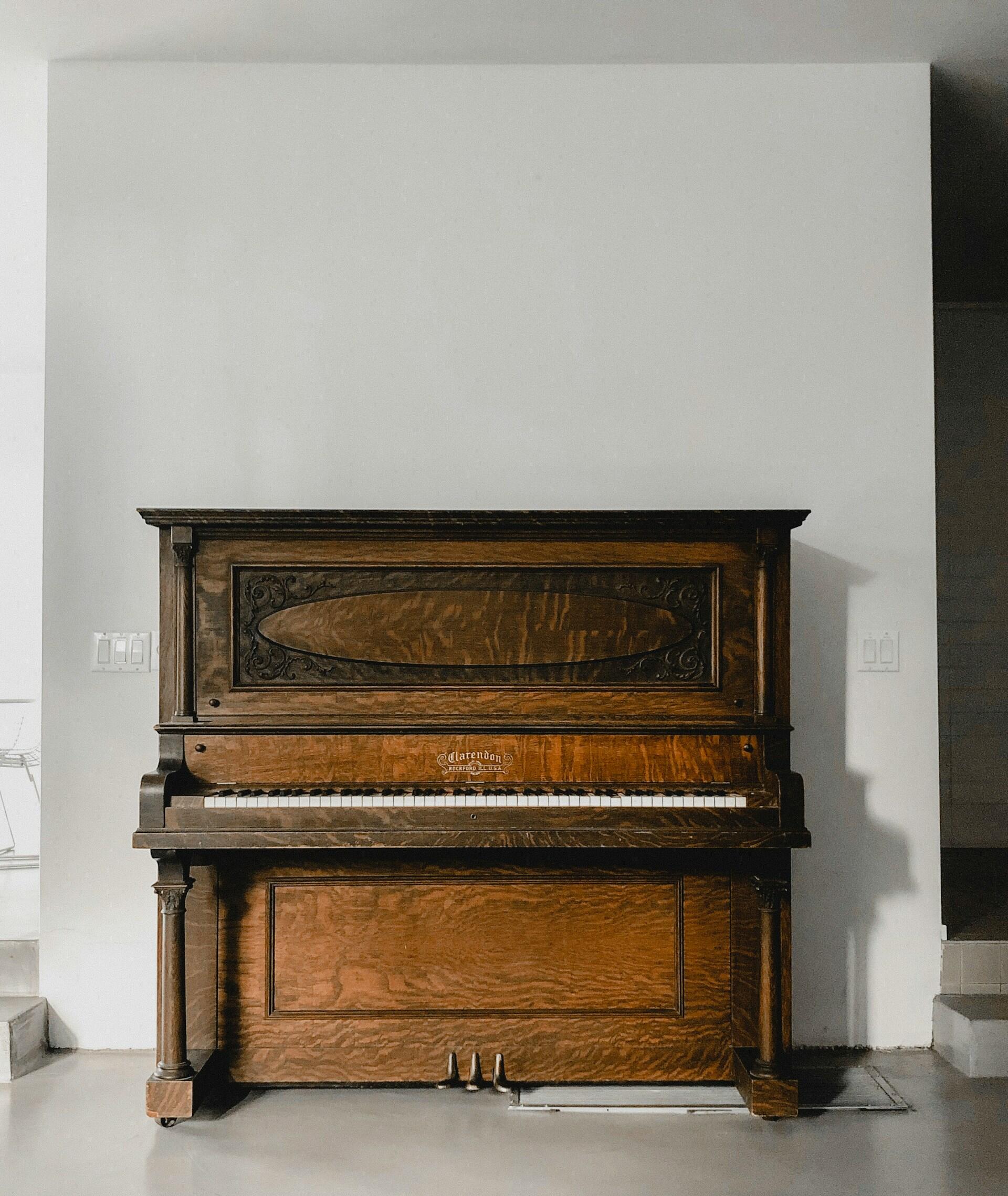 A brown wooden upright piano.