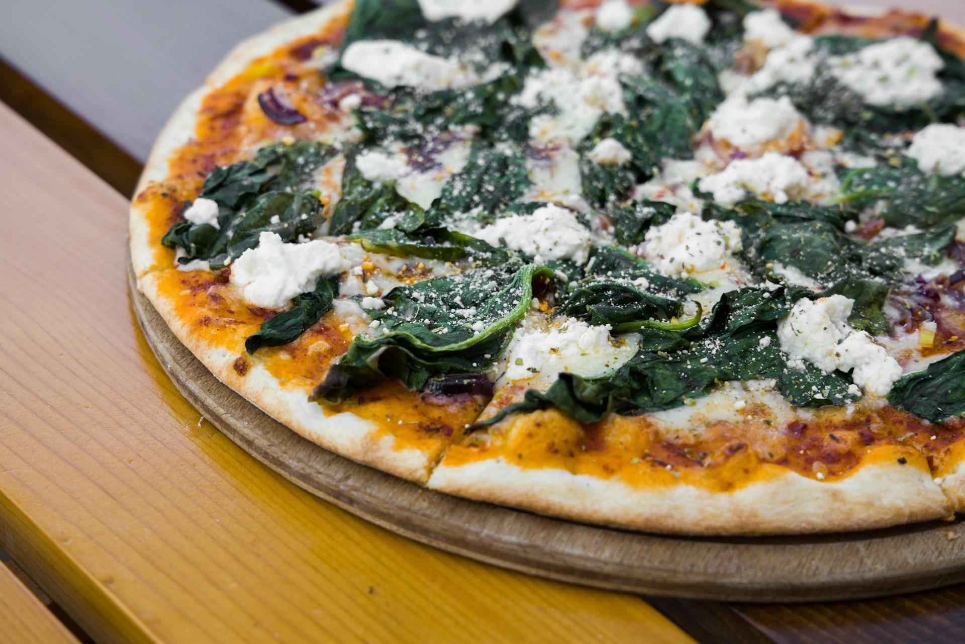 A delicious vegan pizza placed on a rustic wooden table, ready to be savored.