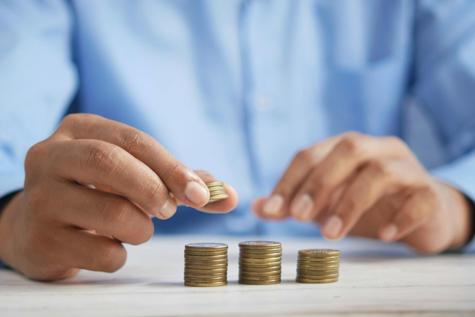 A man counting coins on a table.