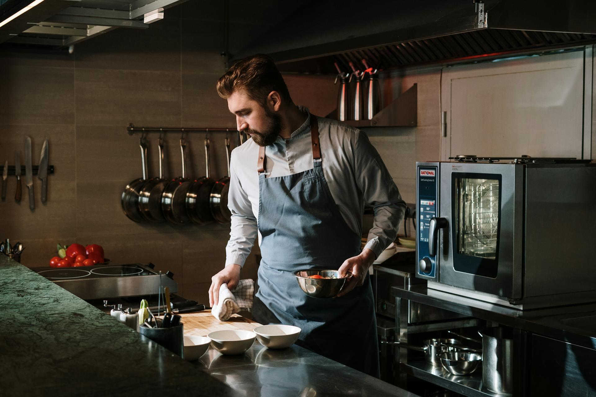 A chef cooking and cleaning in a kitchen