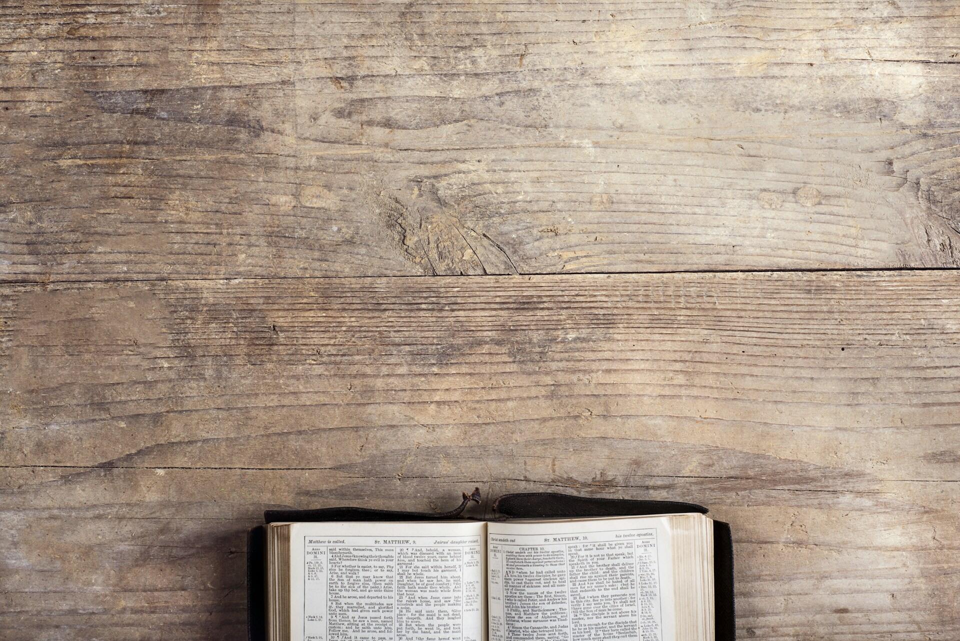 Open book on a rustic wooden background.