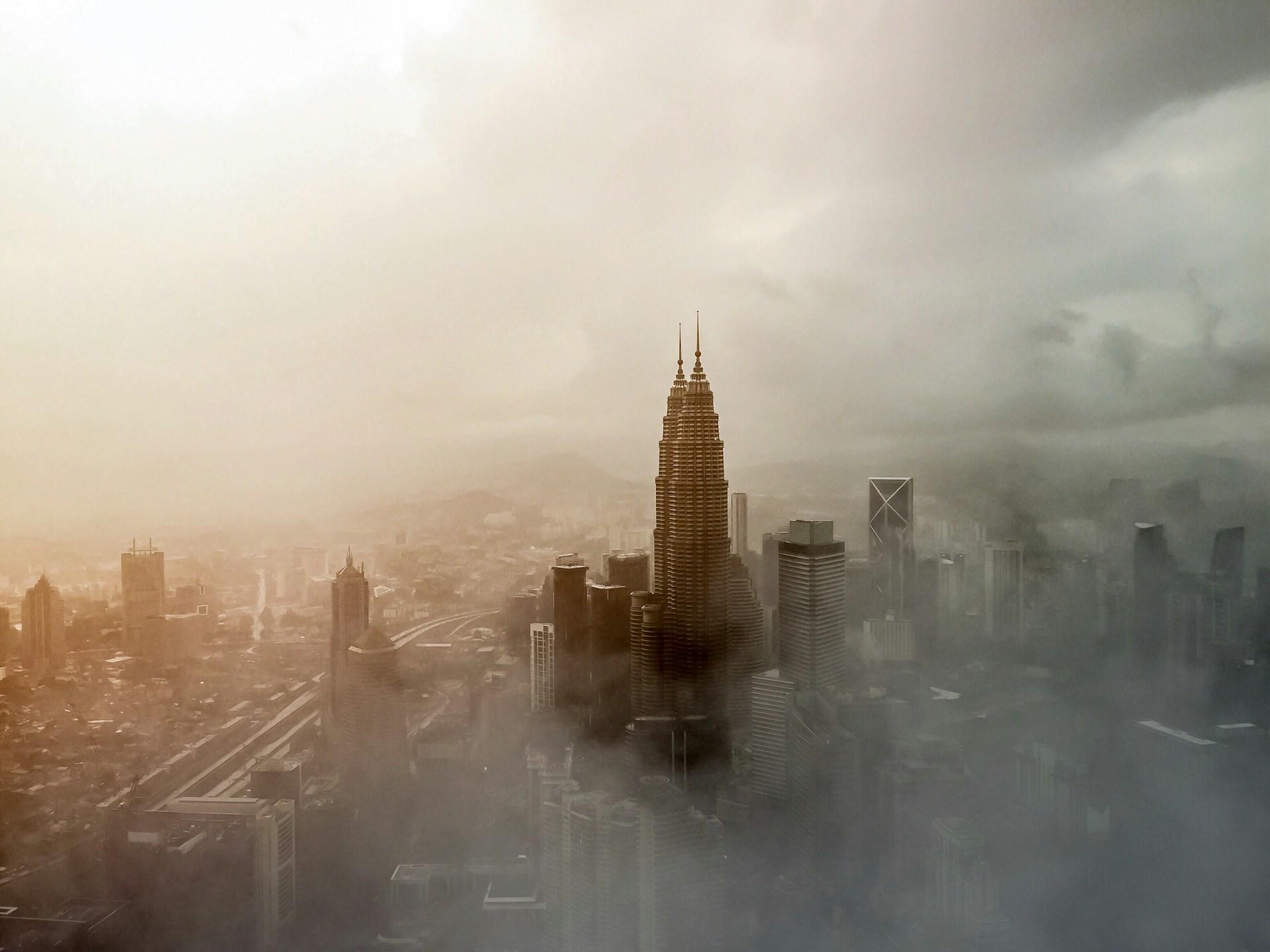 A foggy city skyline, with buildings partially obscured.