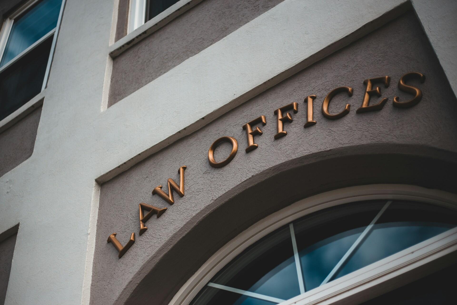 an exterior of an office building with large gold letters reading 