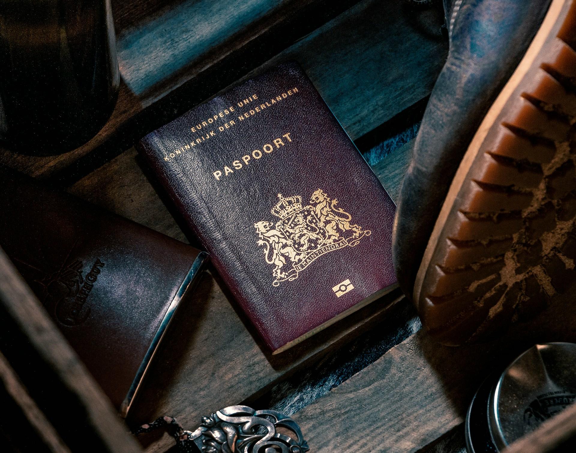 A passport and shoes placed on a wooden box, symbolizing travel and adventure.