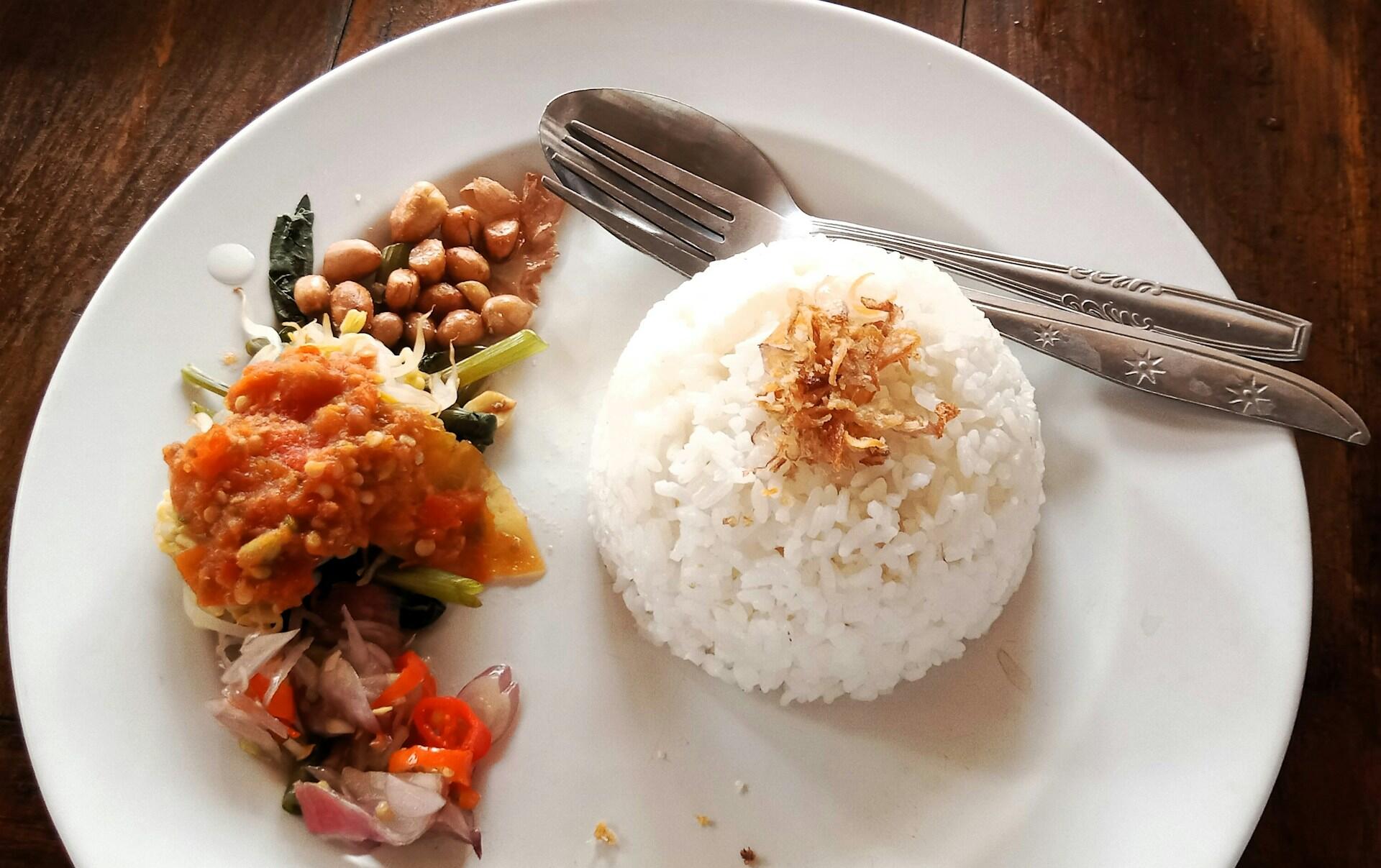 scoop of white rice with a side of vegetables and beans