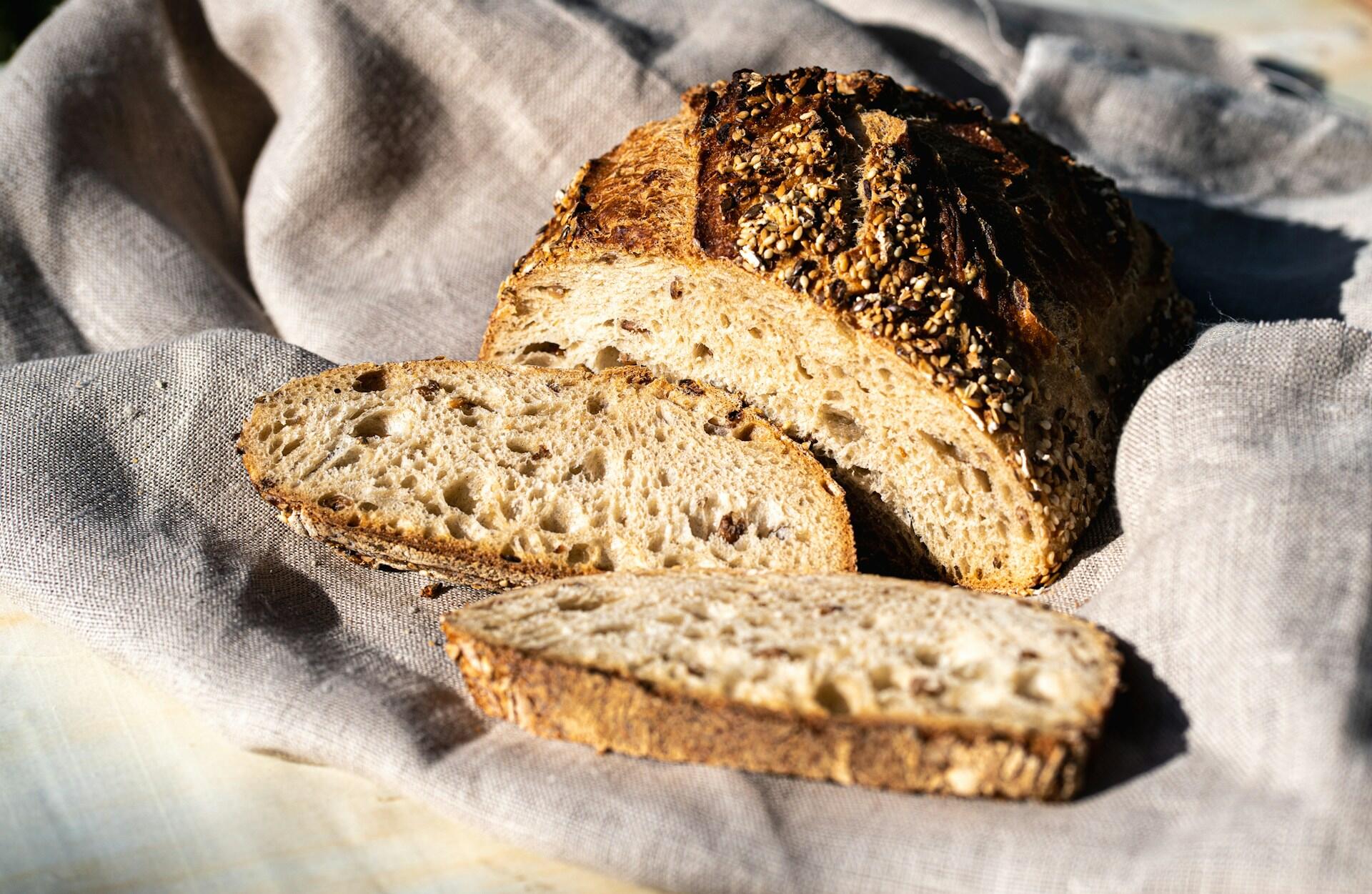 loaf of fresh, homemade bread with lots of seeds and grains on top