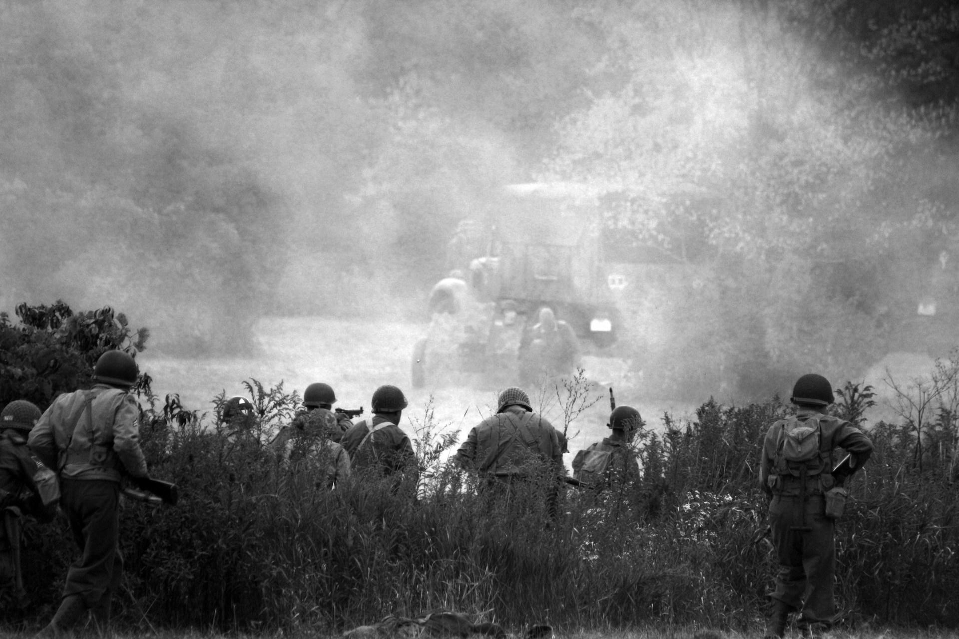 1. Soldiers walking through field with smoke rising.