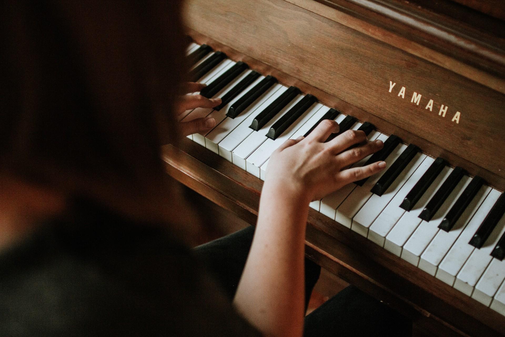 A woman seen from behind playing the piano