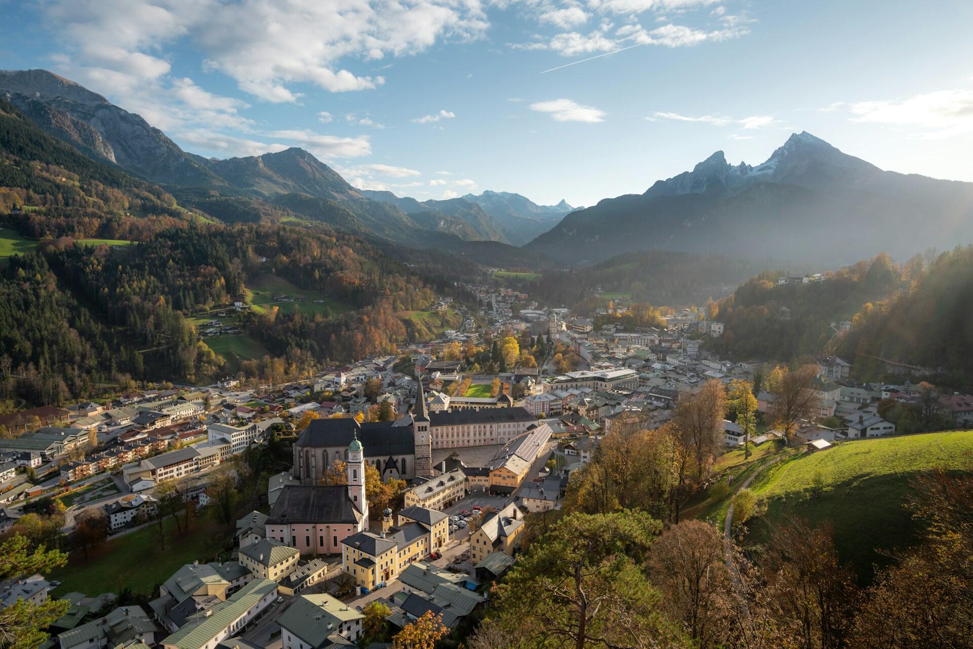 A city surrounded by mountains on a sunny day. 