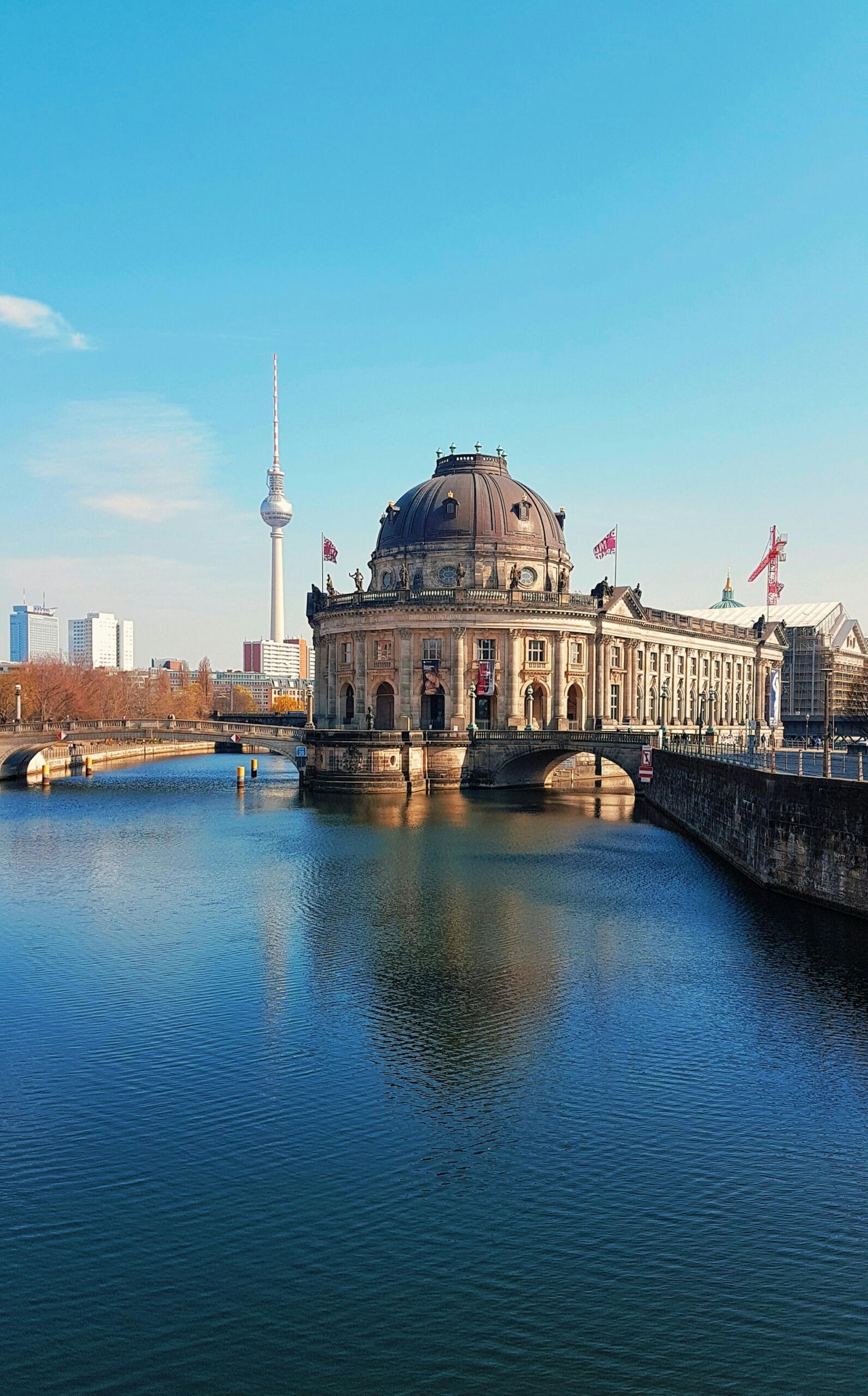 A round stone building with domed roof on the water.