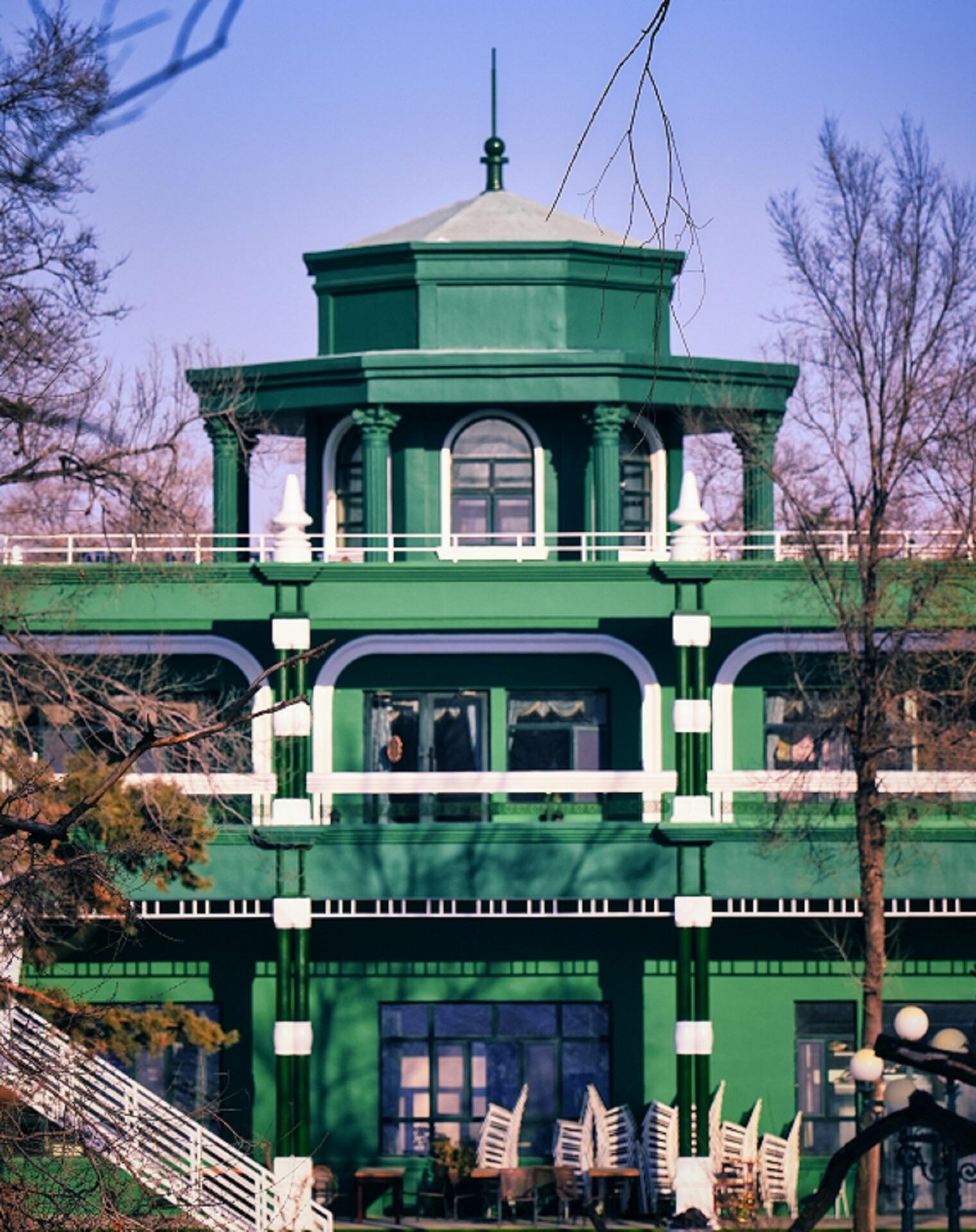A green building on a sunny day.