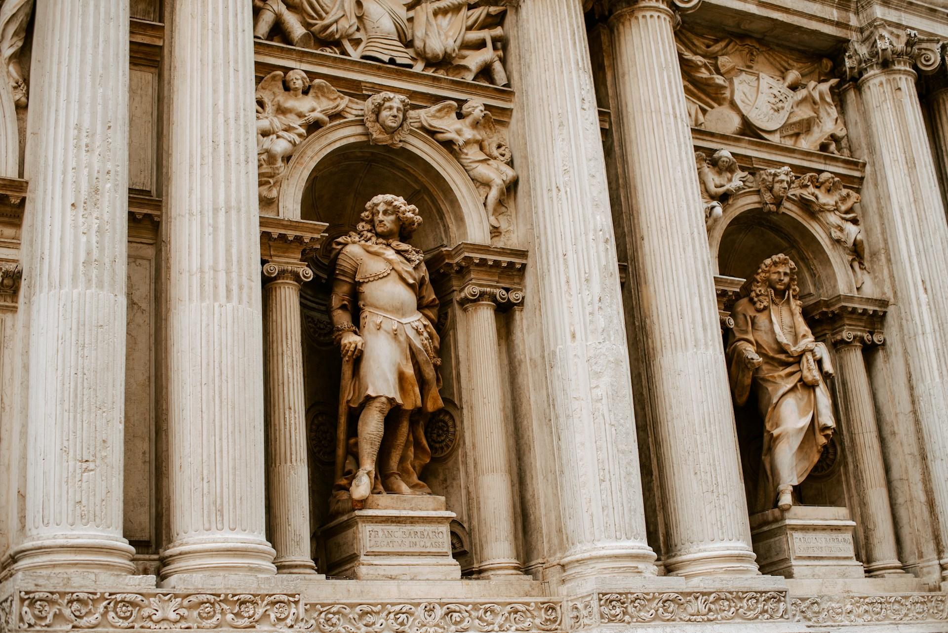 Statues set in alcoves in a building's facade.