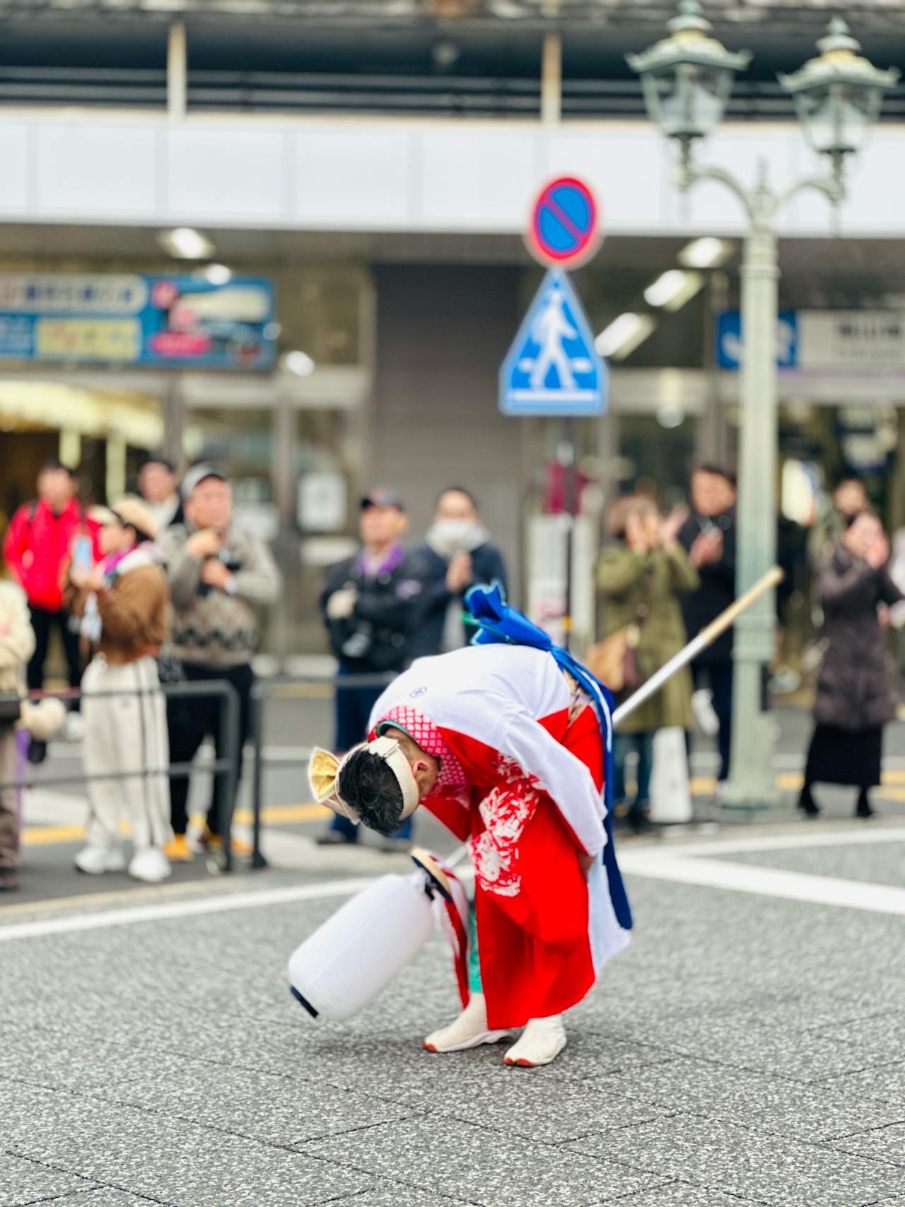 A Japanese performer bowing deeply to the audience