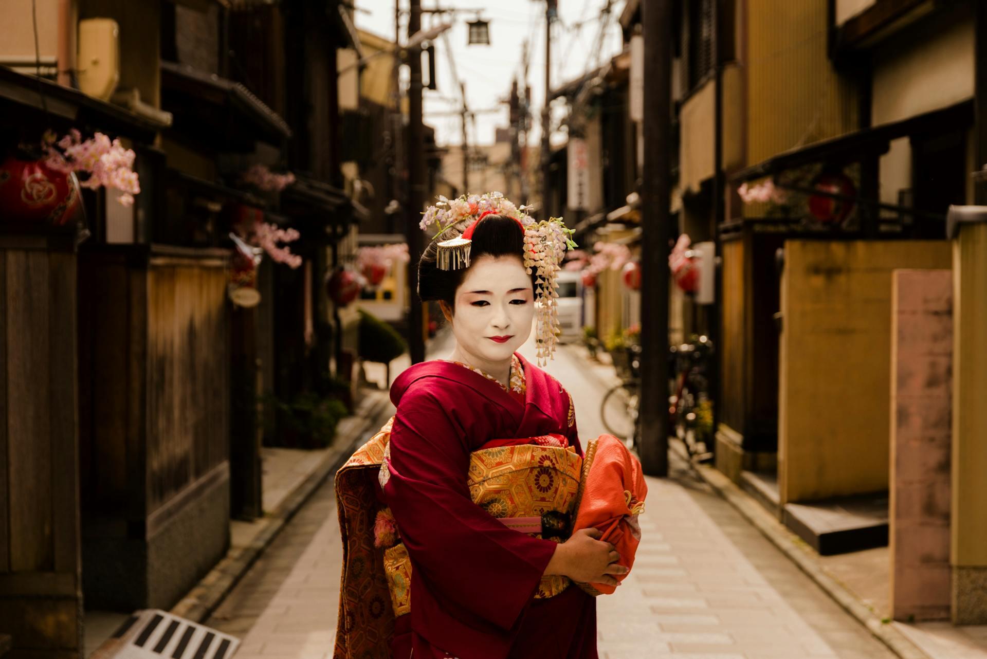 Geisha or maiko standing in a Kyoto street with full dress and makeup