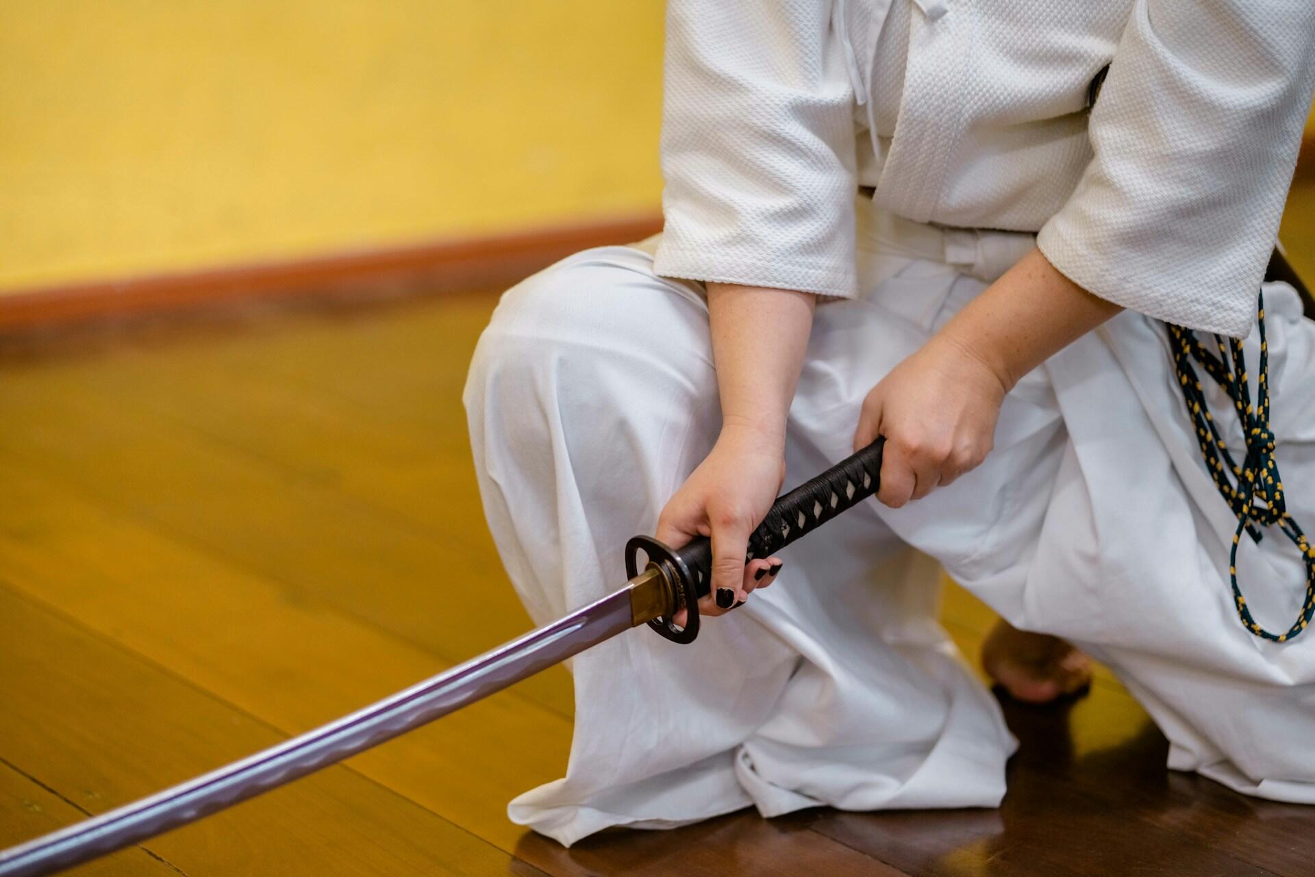 a kenjutsu student wearing a white ghi and holding a katana