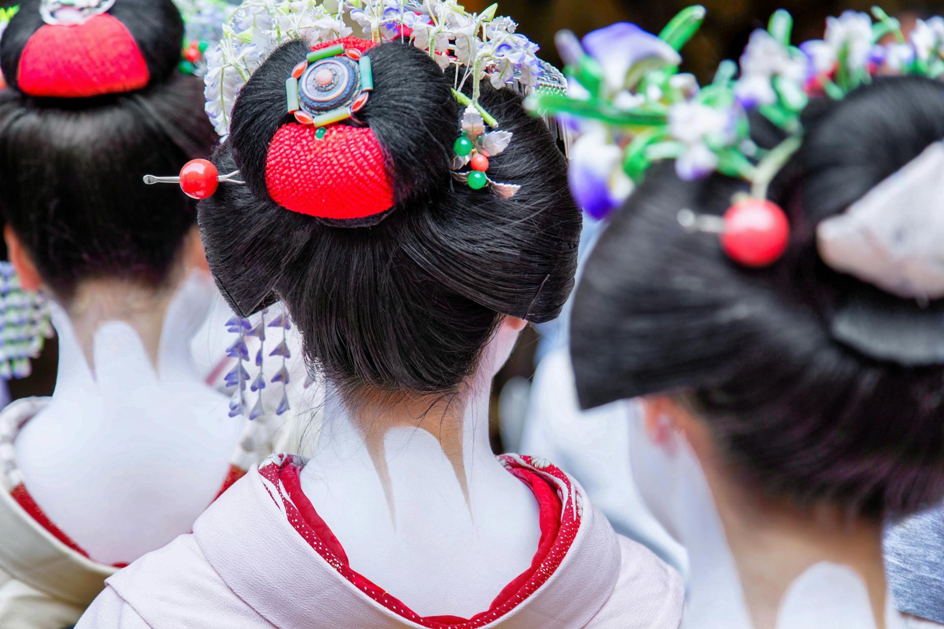 Three maiko as evidenced by their hairstyles which have elaborate hairpins and a bun with red cloth inside