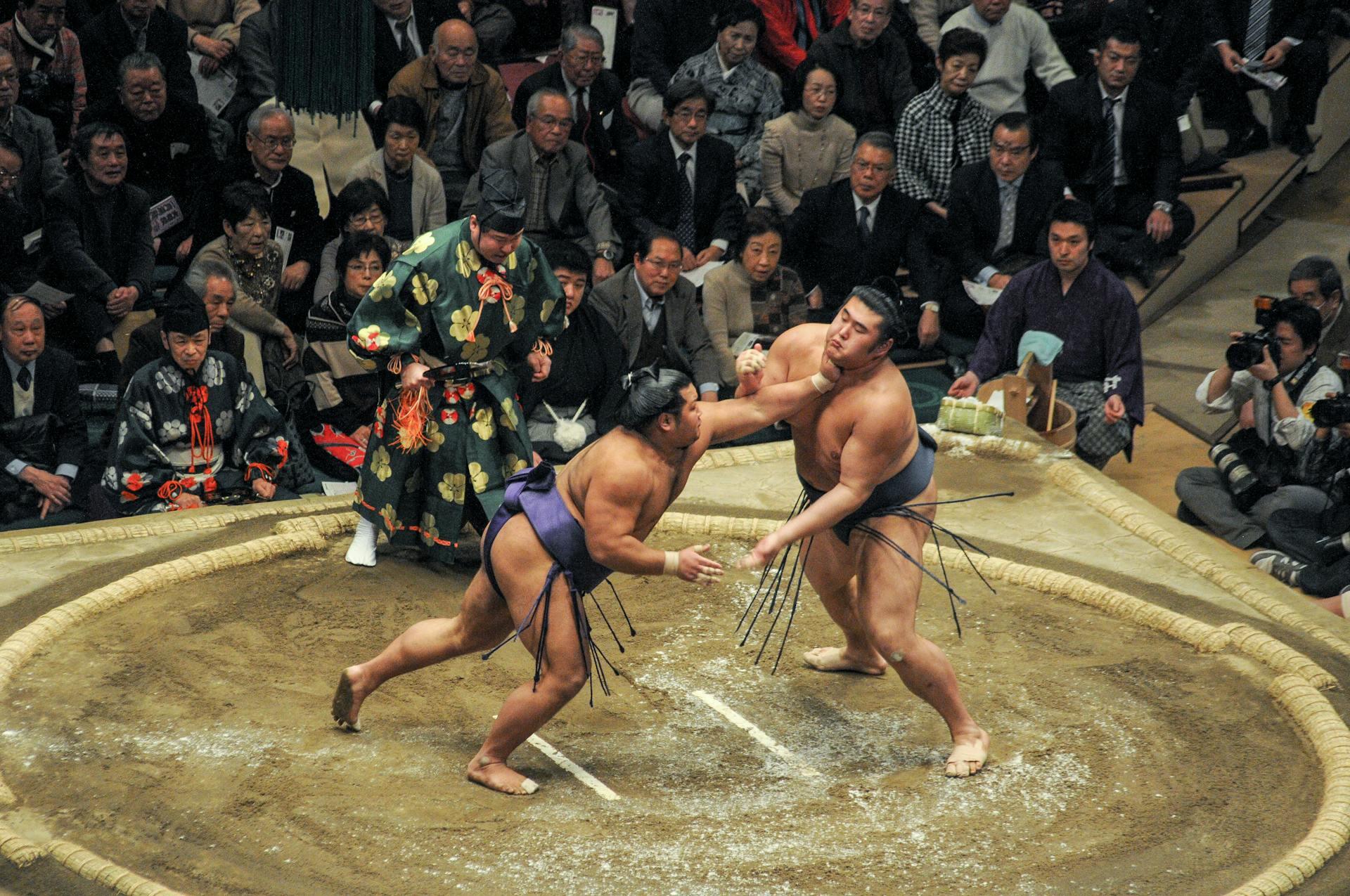 sumo wrestlers striking each other in a match