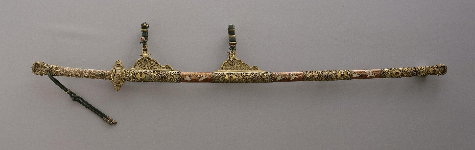 A sword and sheath with gold decorations. 