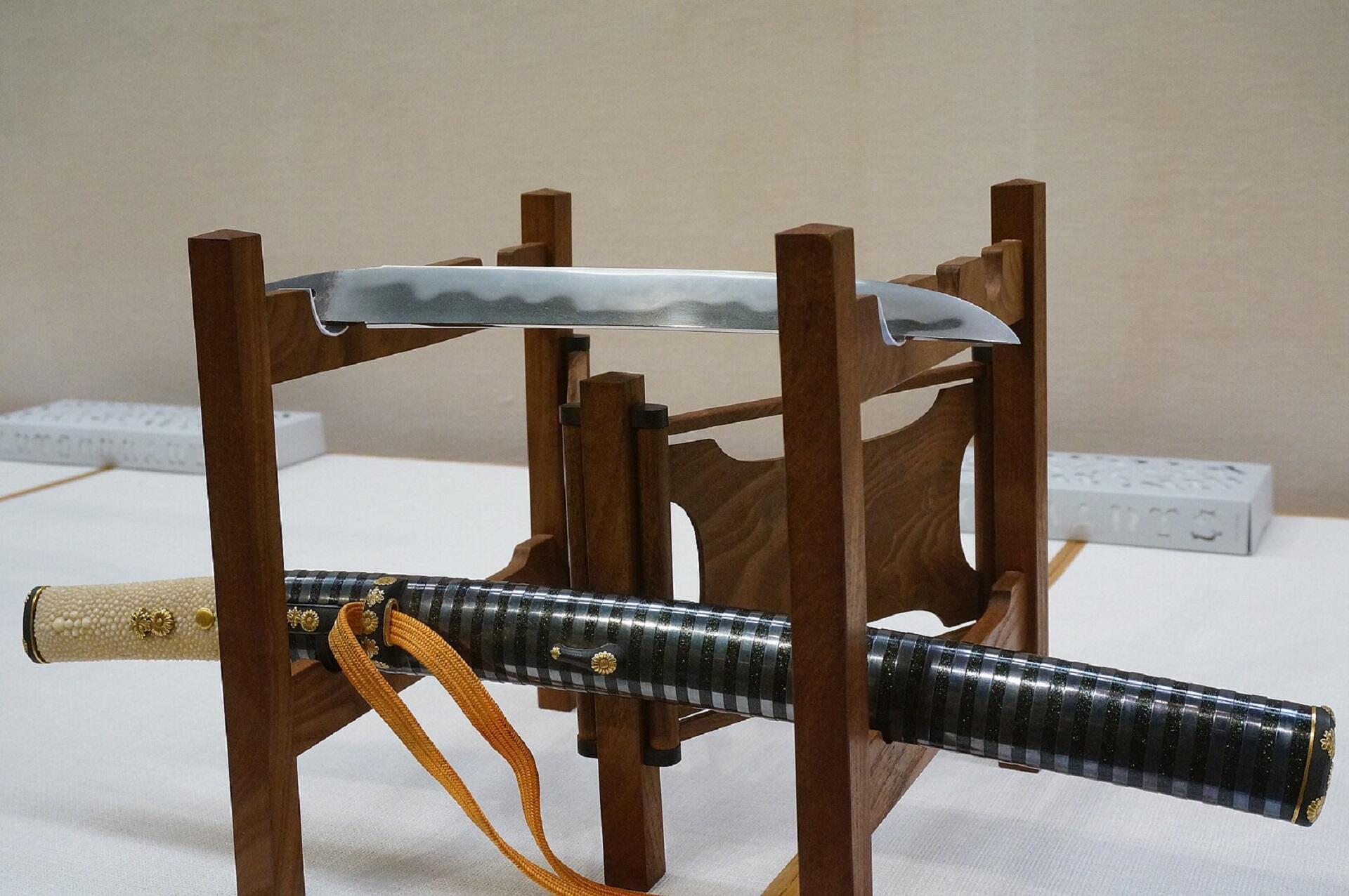 A display of a Japanese tanto on a wooden stand. 