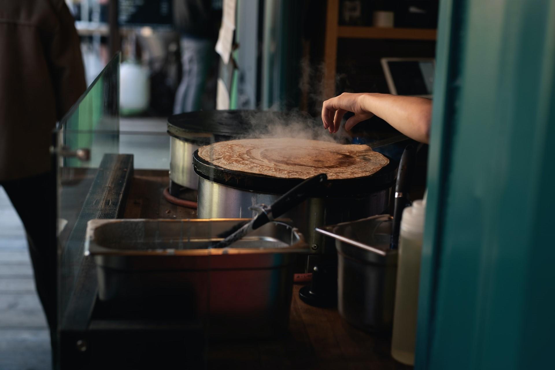 A crepe vendor using a crepe maker.