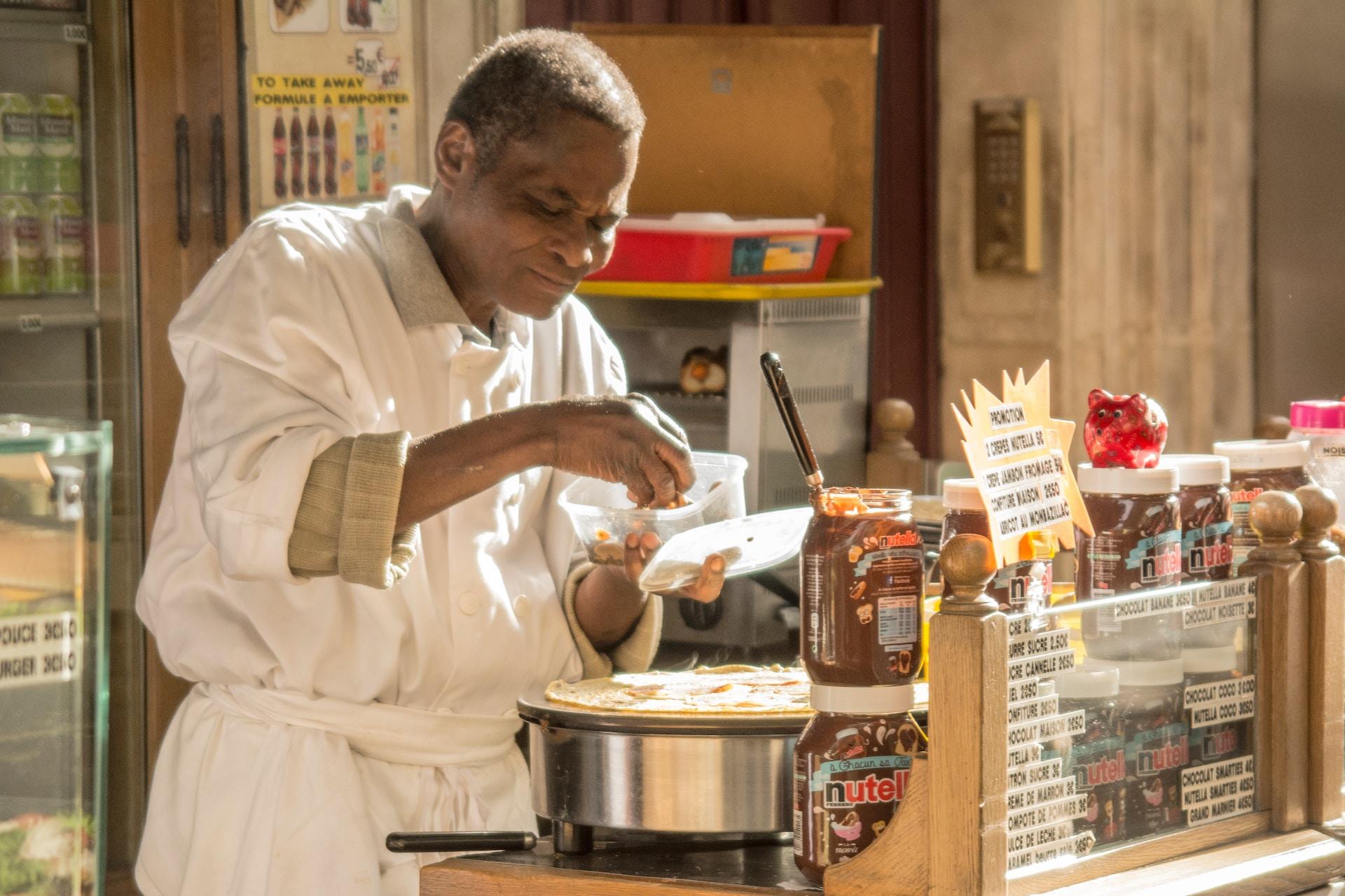 A crepe vendor surrounded by toppings.