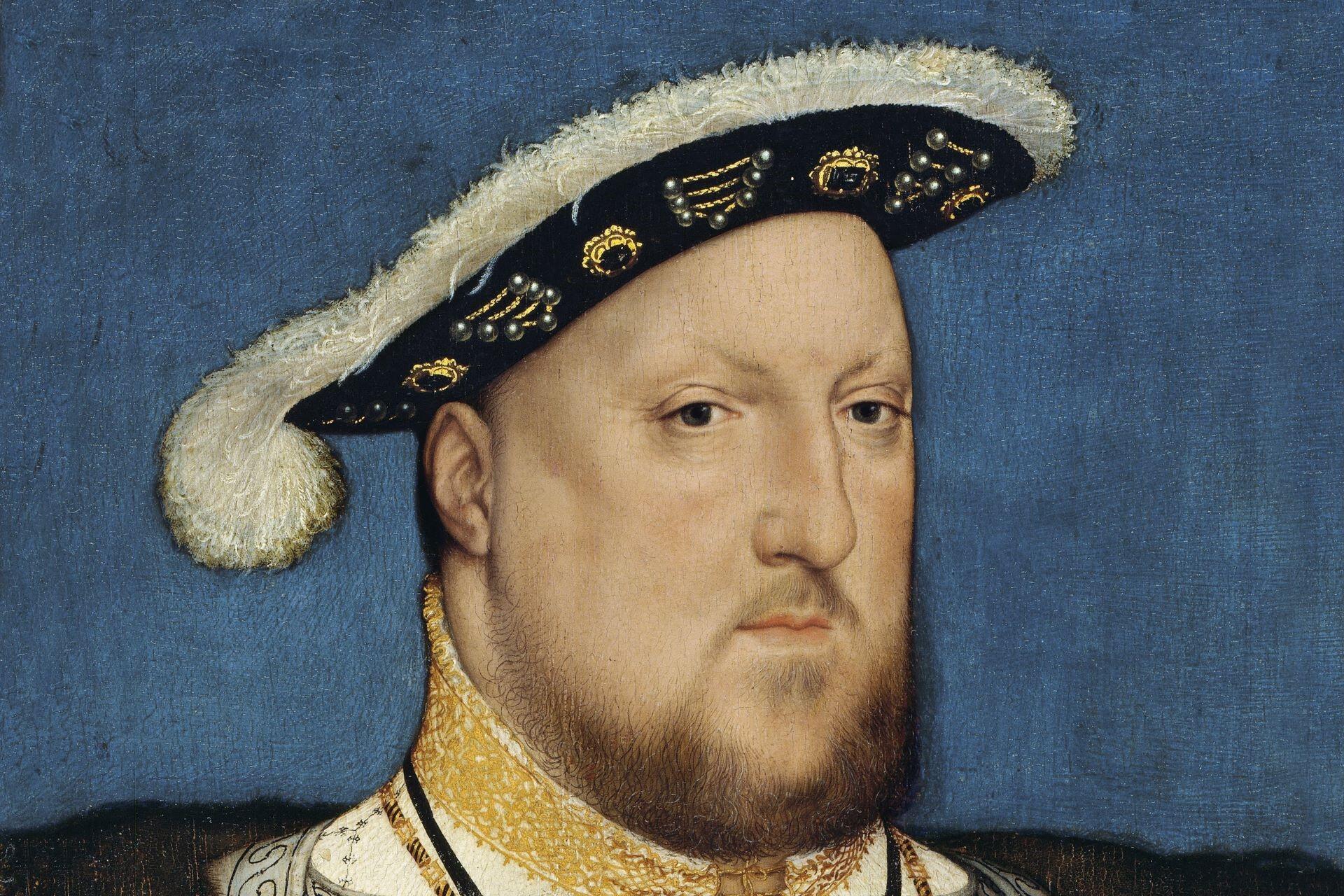 Close-up painted portrait of a bearded man wearing a decorated Tudor hat with fur trim, ornate clothing, and a gold embroidered collar against a blue background.