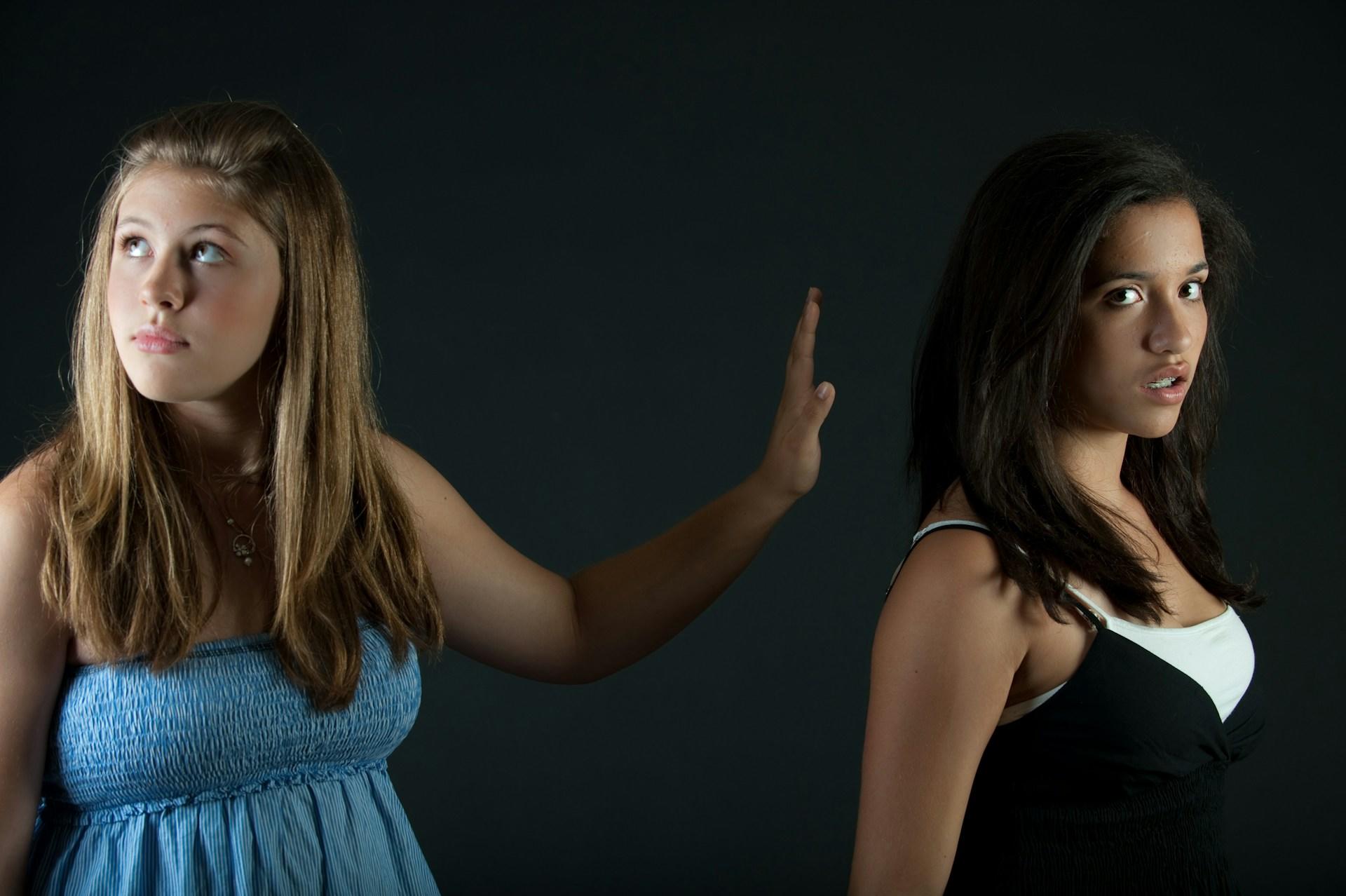 Two young women smiling and standing side by side.
