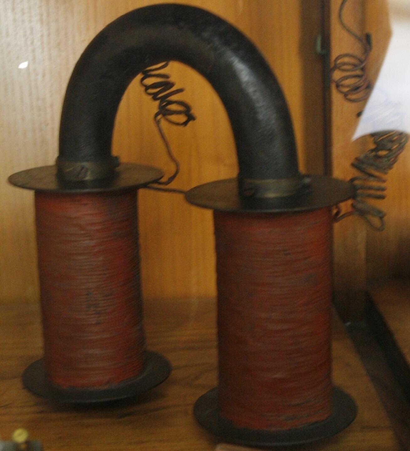 Two copper coils joined by a U-shaped iron bar.