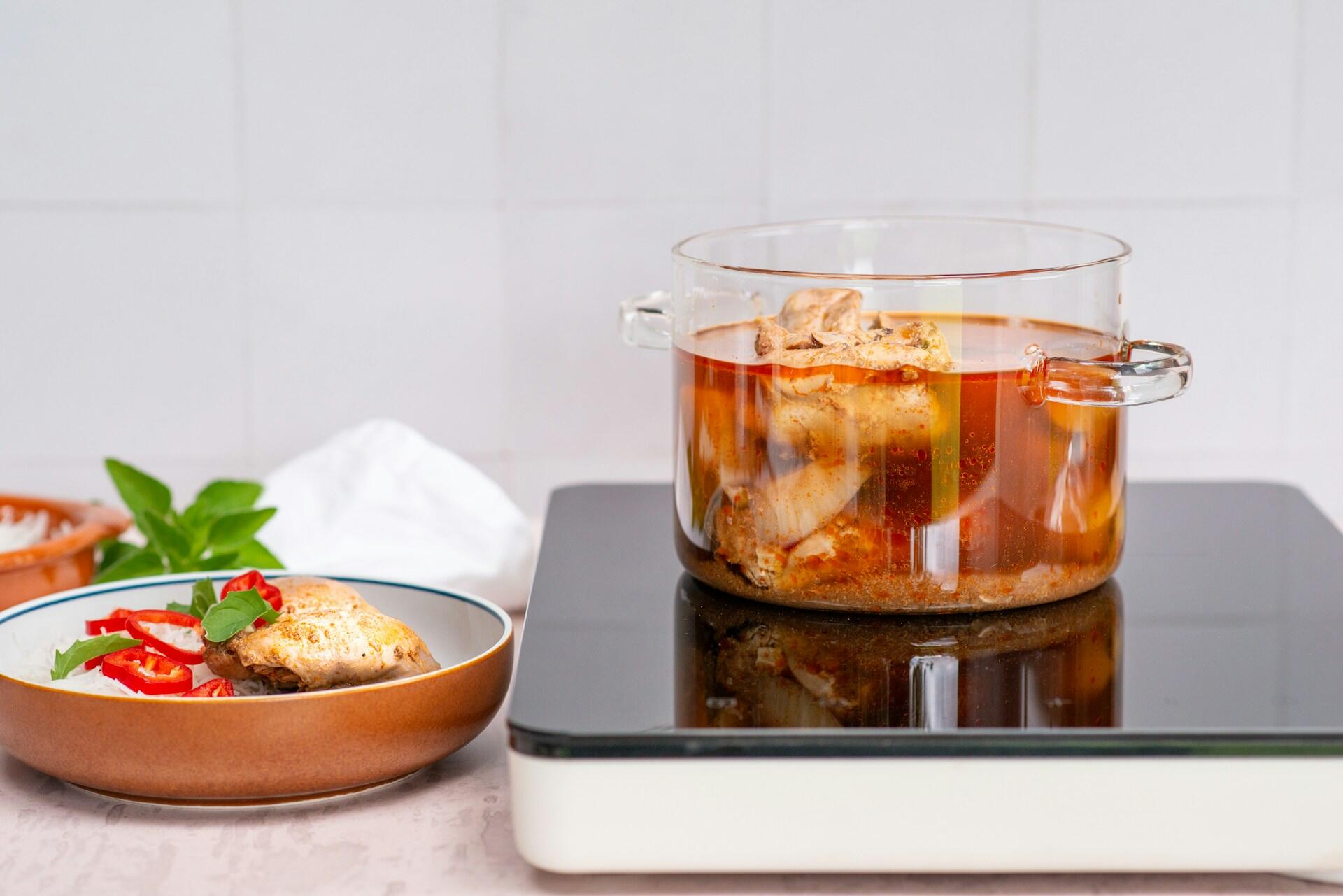 A full glass pot on a cooker.