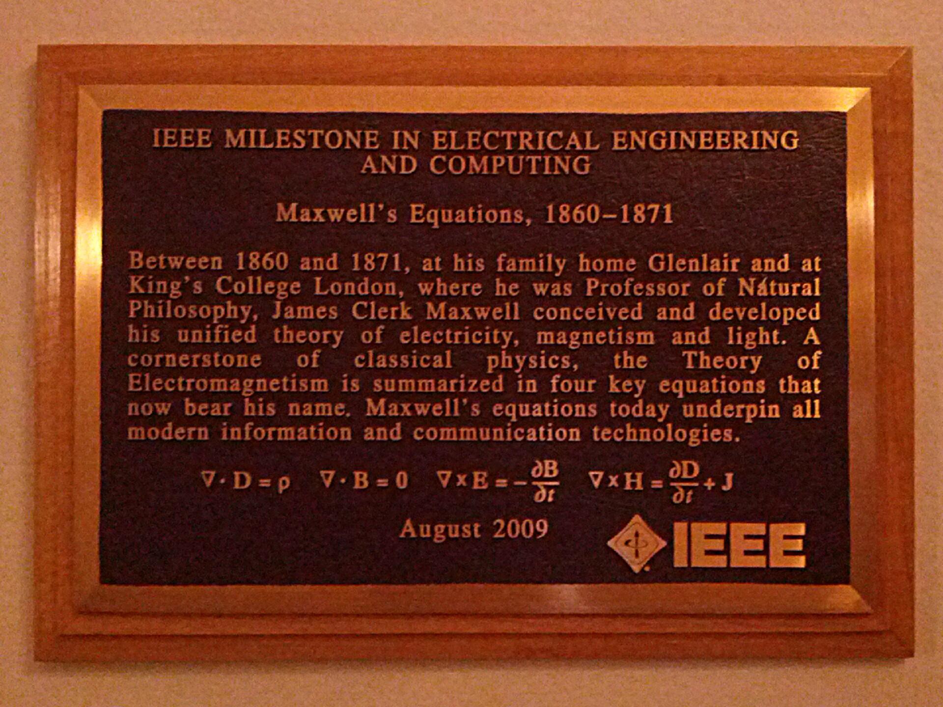 A bronze plaque with mathematical equations and and explanation on it.