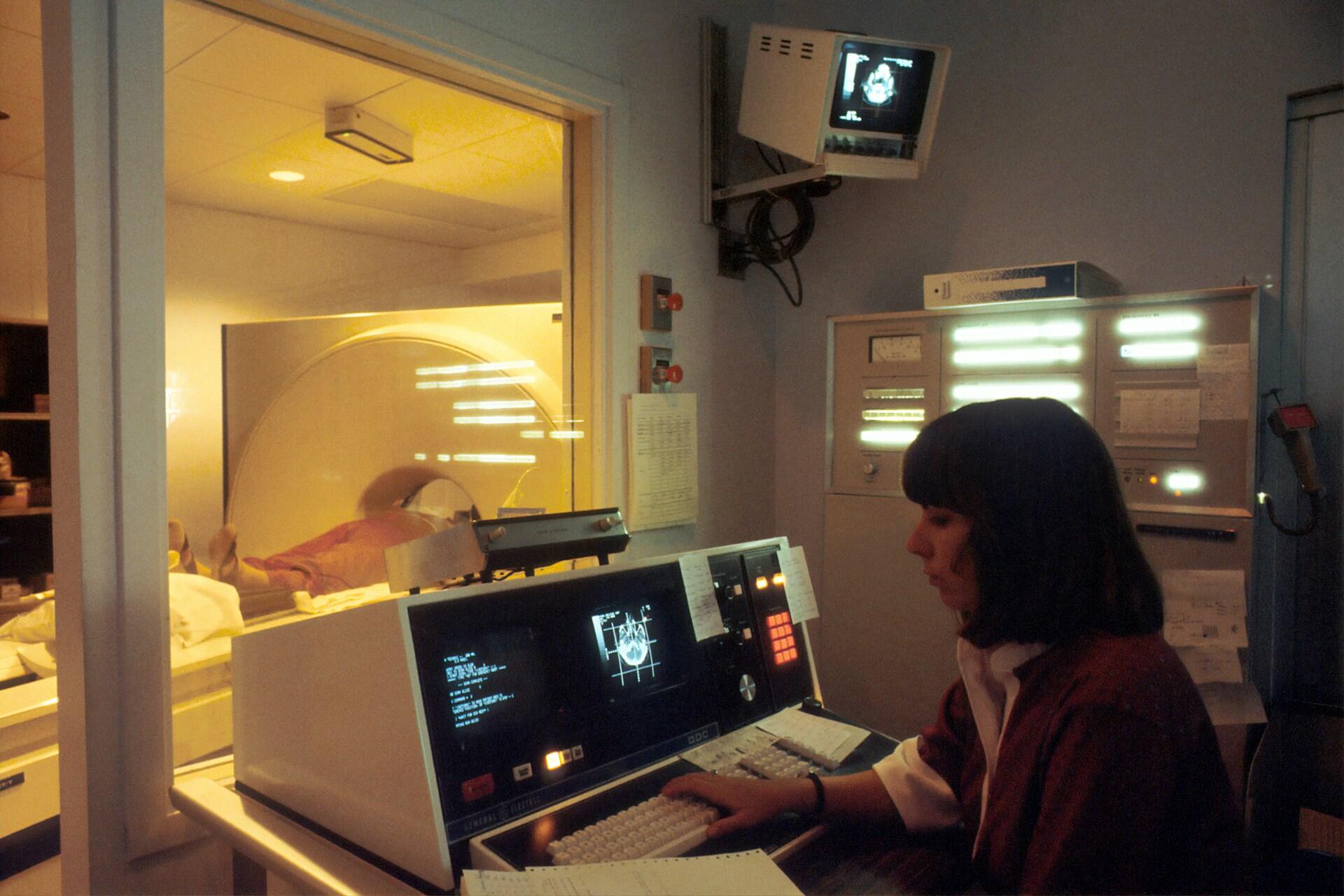 An operator at an MRI control panel. 