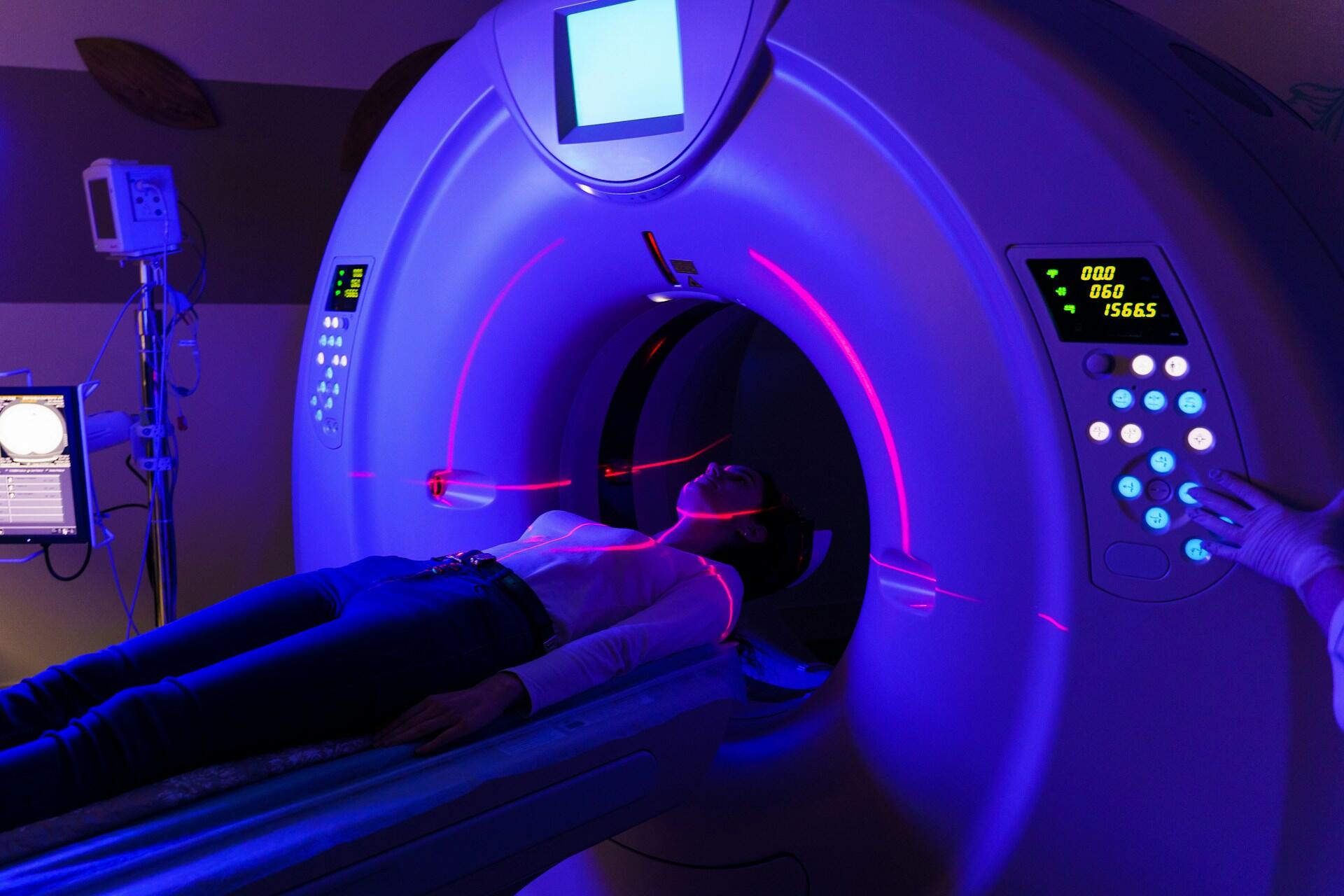 A patient on an MRI table and a tech setting parameters. 