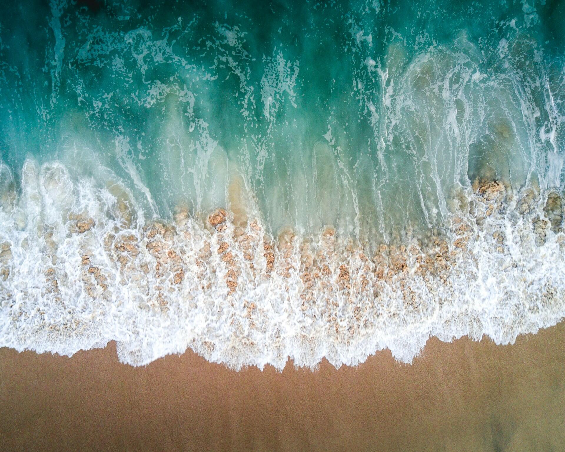 An ocean wave rolling onto the shore. 
