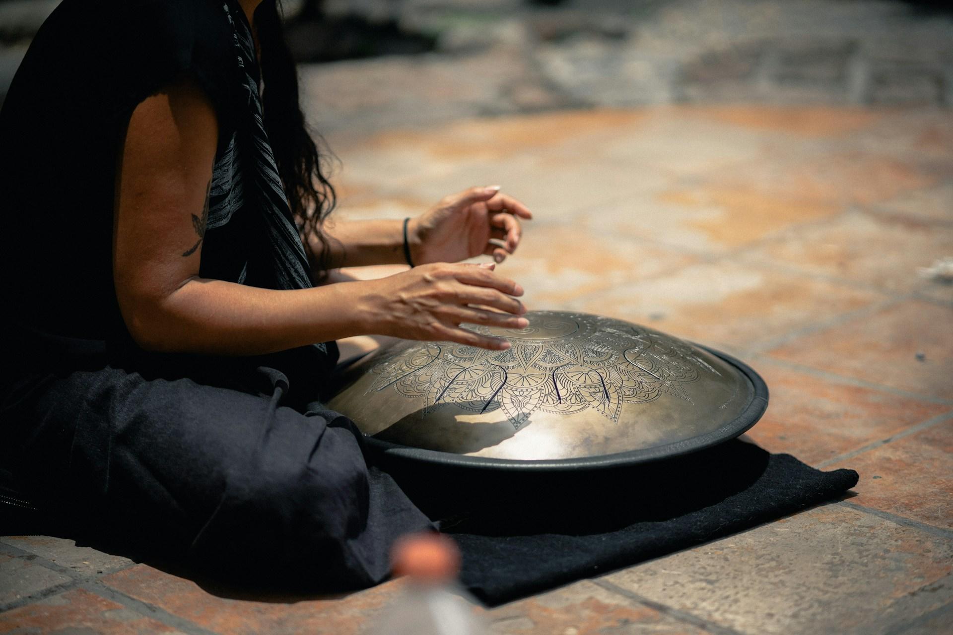 Close up of a person playing a hang drum.