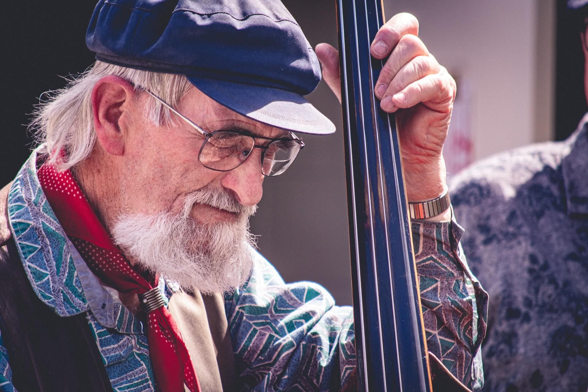 A man playing the double bass out of doors