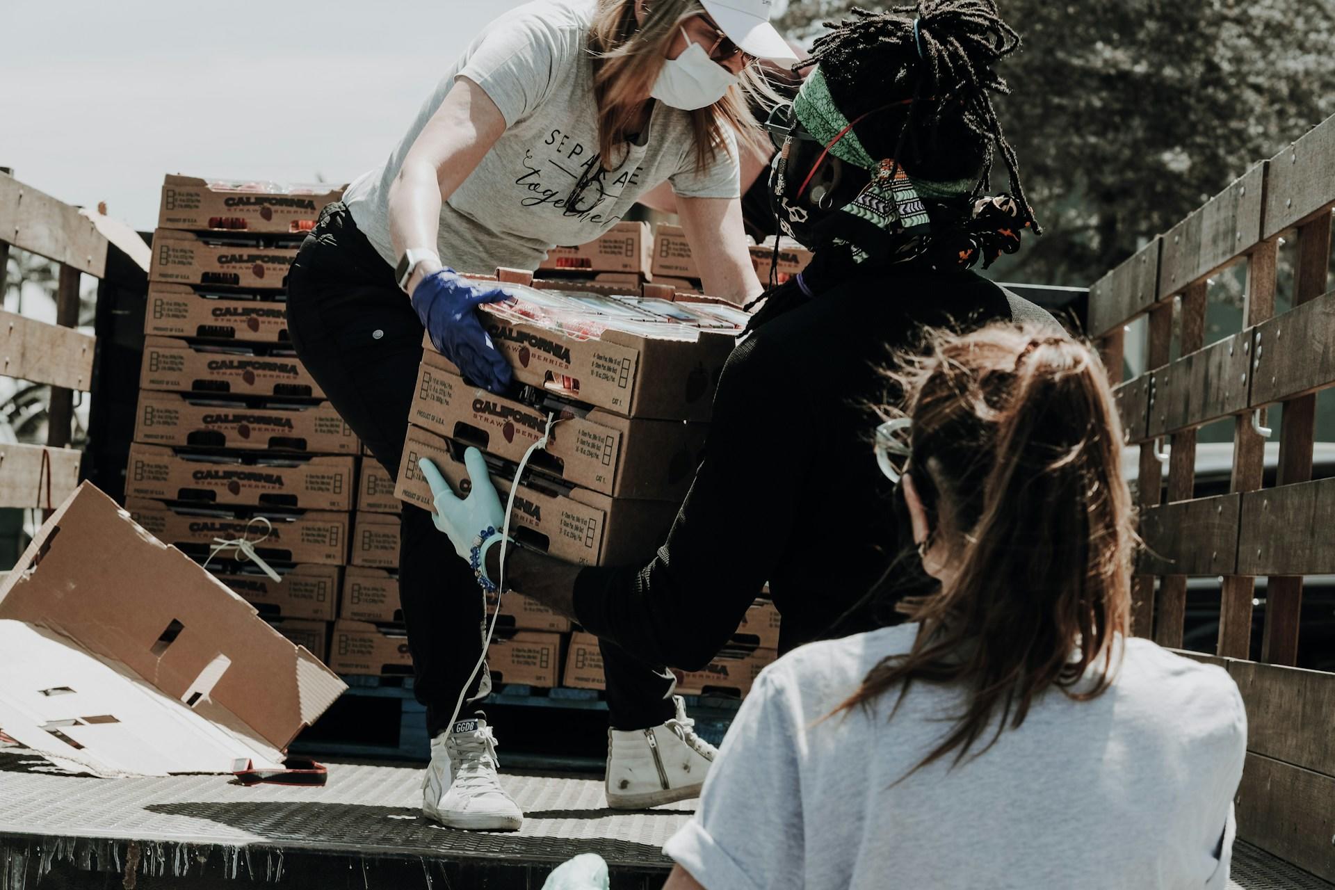 A person helping unload produce from the back of a truck.