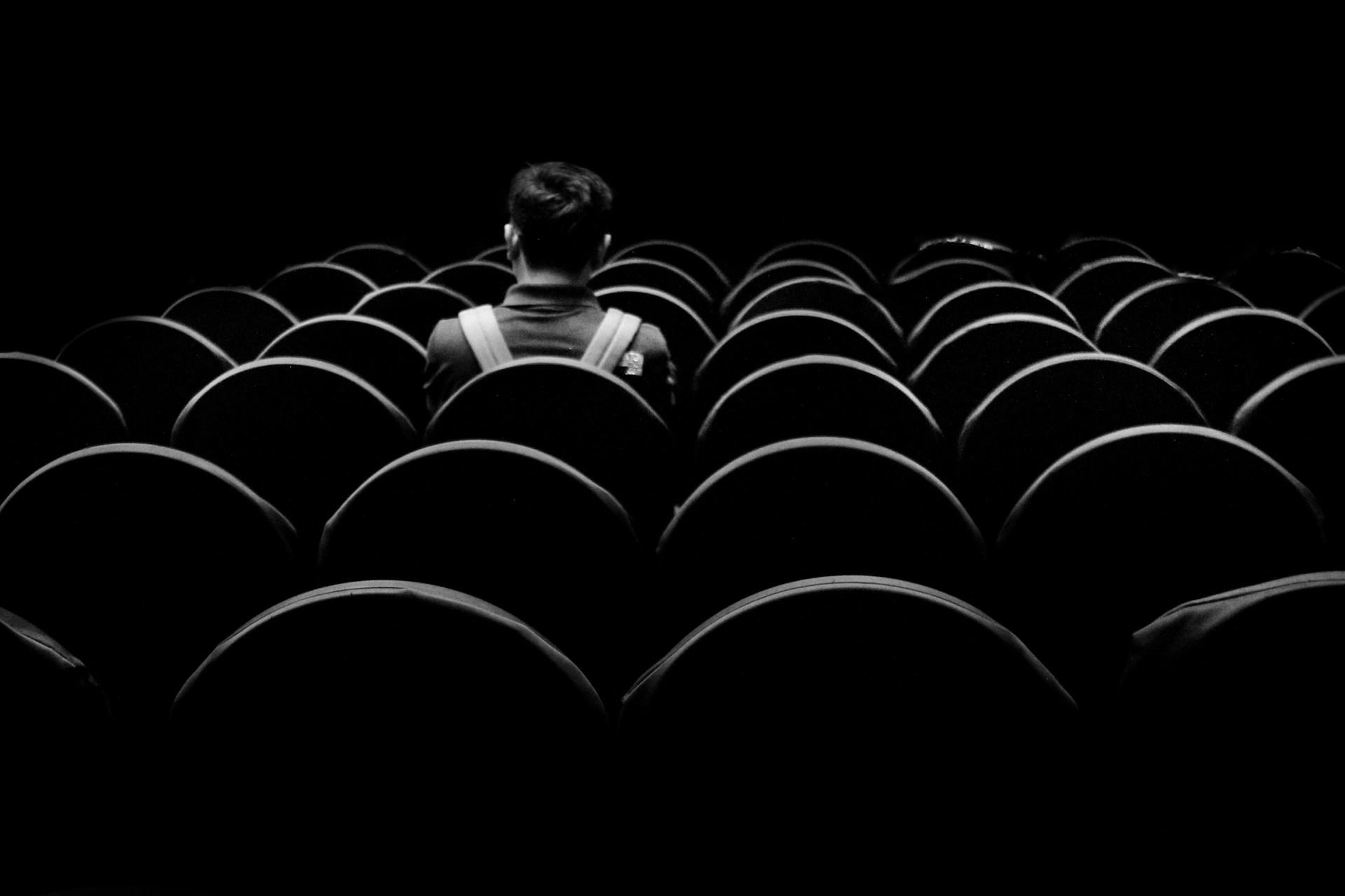 A single person sitting in a cinema.