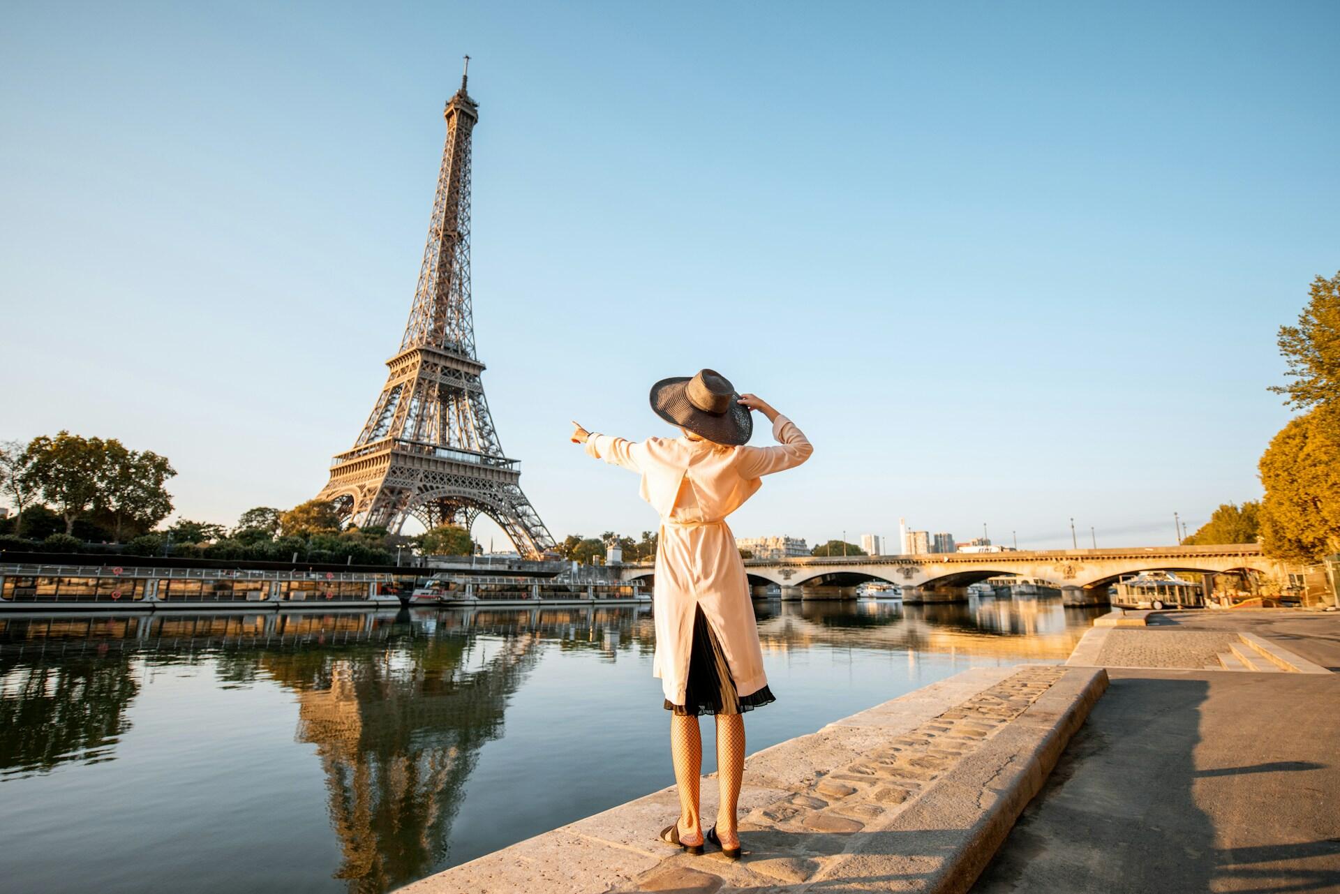 an excited tourist points to the Eiffel Tower in the distance