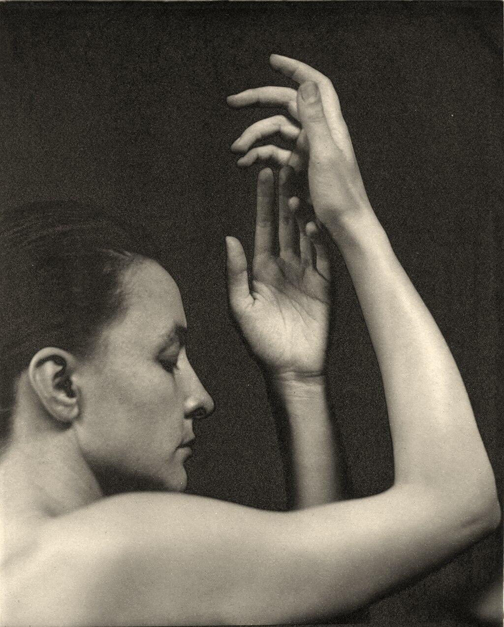 a black and white artistic photograph of O'Keeffe in her youth, as photographed by Stieglitz in 1920
