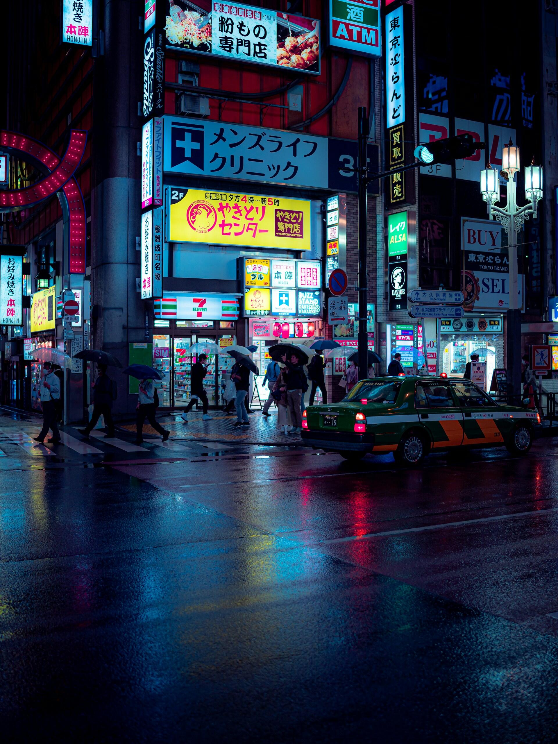 A Japanese street at night with lit up signs showing Katakana writing.
